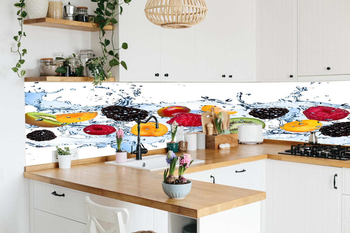 Küche - Farbenfrohes Obst Splash hinter weißen Hochglanz-Küchenregalen und schwarzem Wasserhahn