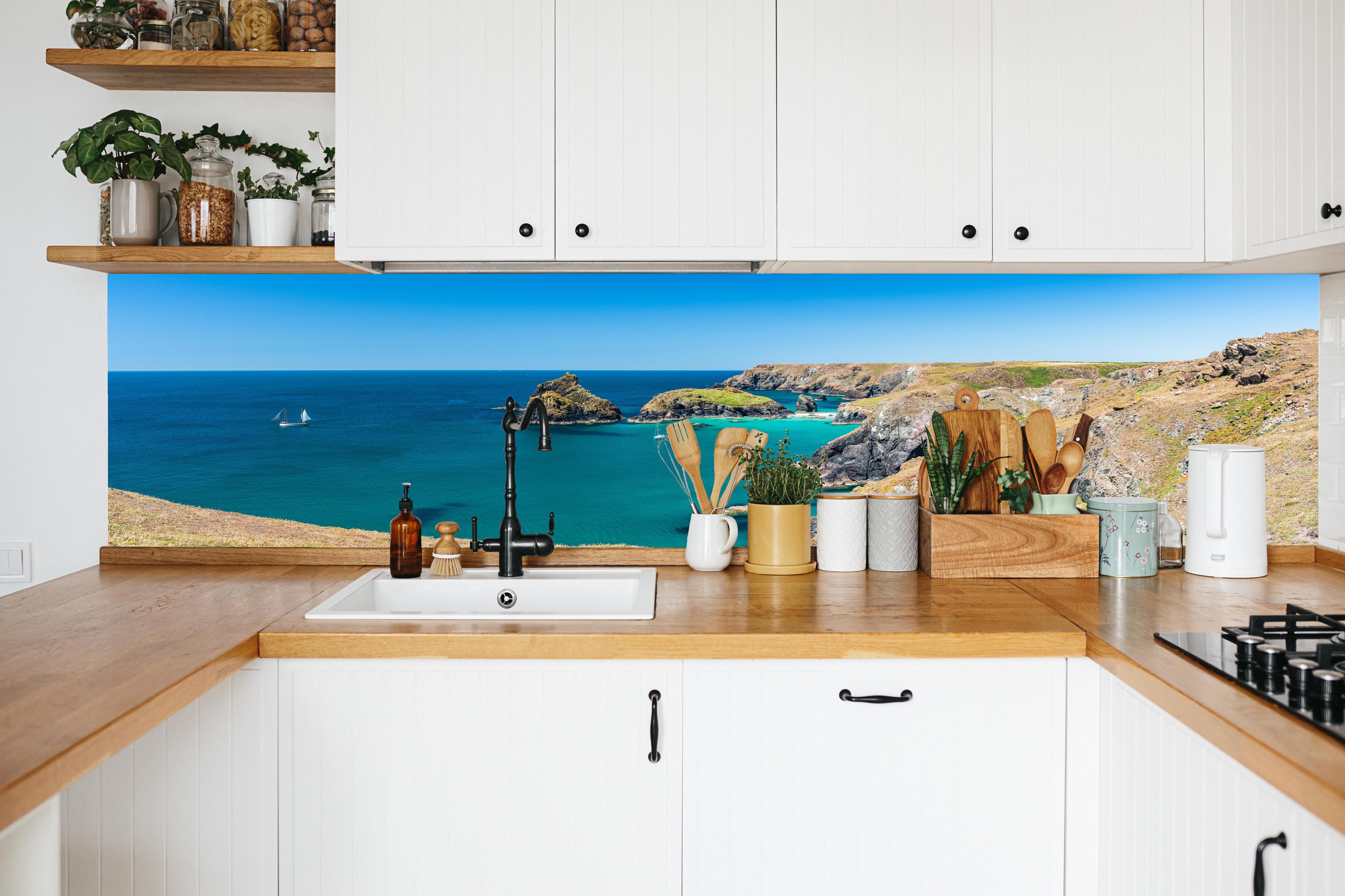 Küche - Faszinierende Aussicht auf eine Küstenlandschaft mit klarem, türkisem Wasser hinter weißen Hochglanz-Küchenregalen und schwarzem Wasserhahn