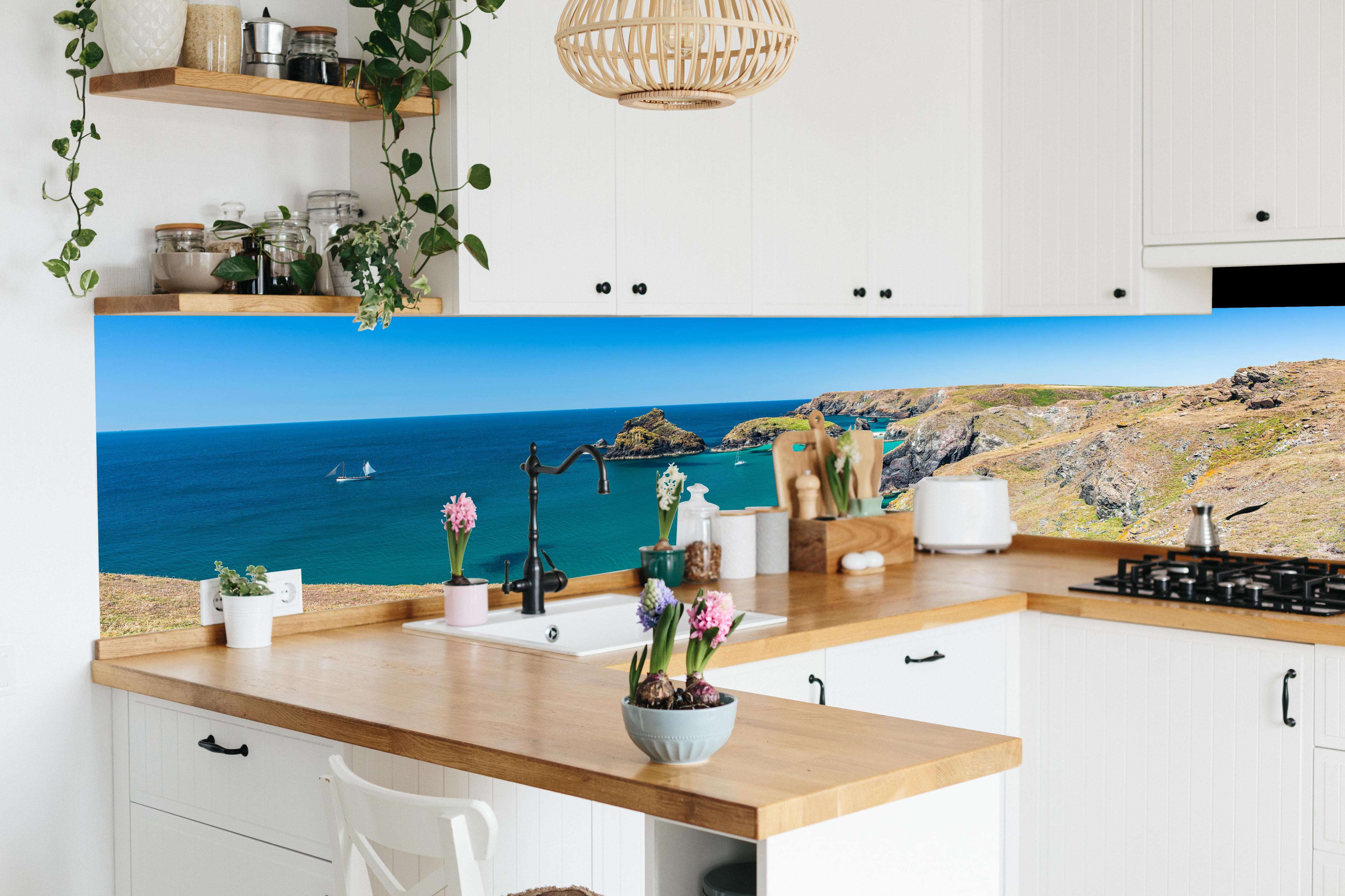 Küche - Faszinierende Aussicht auf eine Küstenlandschaft mit klarem, türkisem Wasser hinter weißen Hochglanz-Küchenregalen und schwarzem Wasserhahn