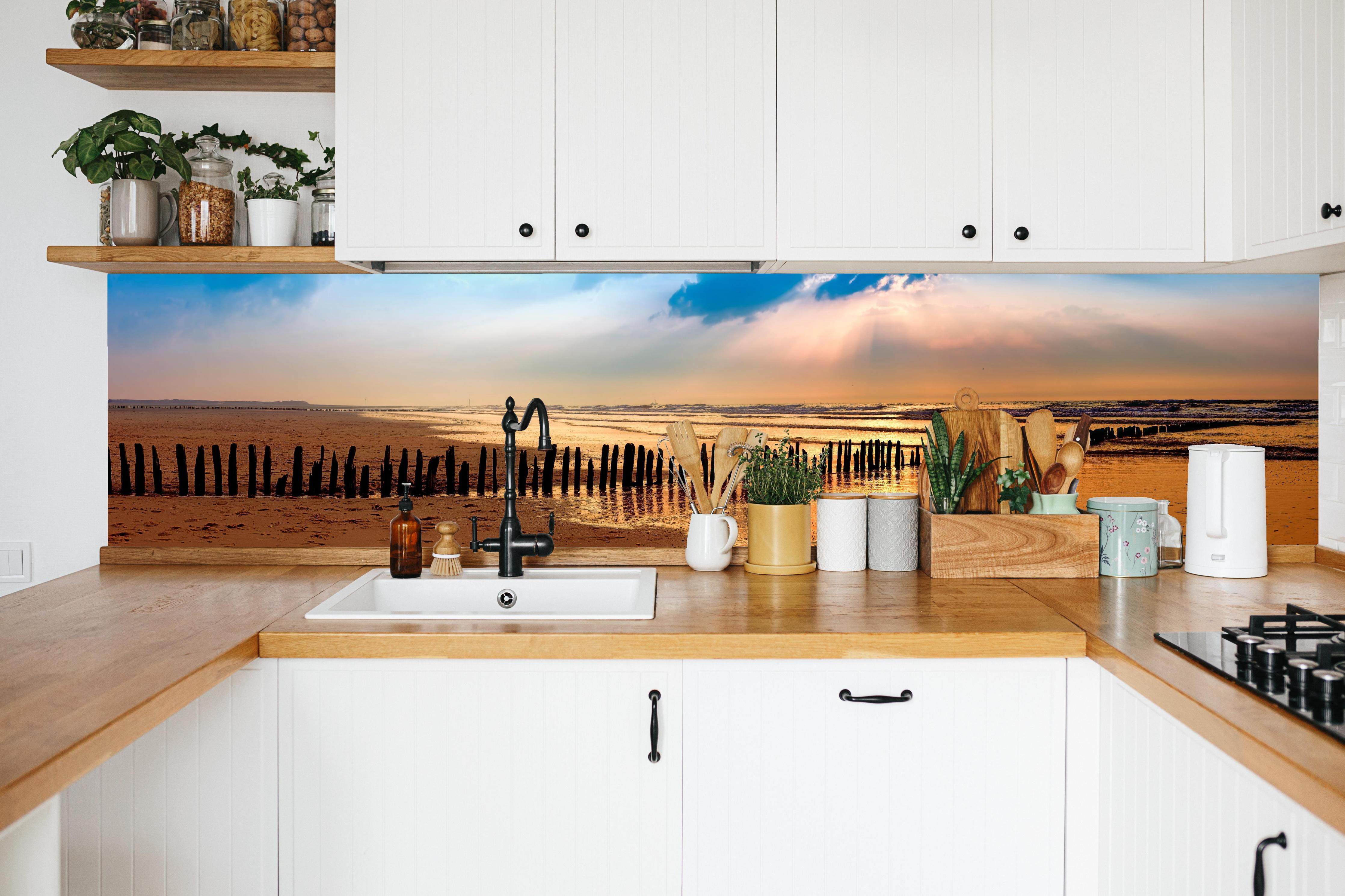 Küche - Faszinierender Sonnenuntergang über dem ruhigen Meer hinter weißen Hochglanz-Küchenregalen und schwarzem Wasserhahn