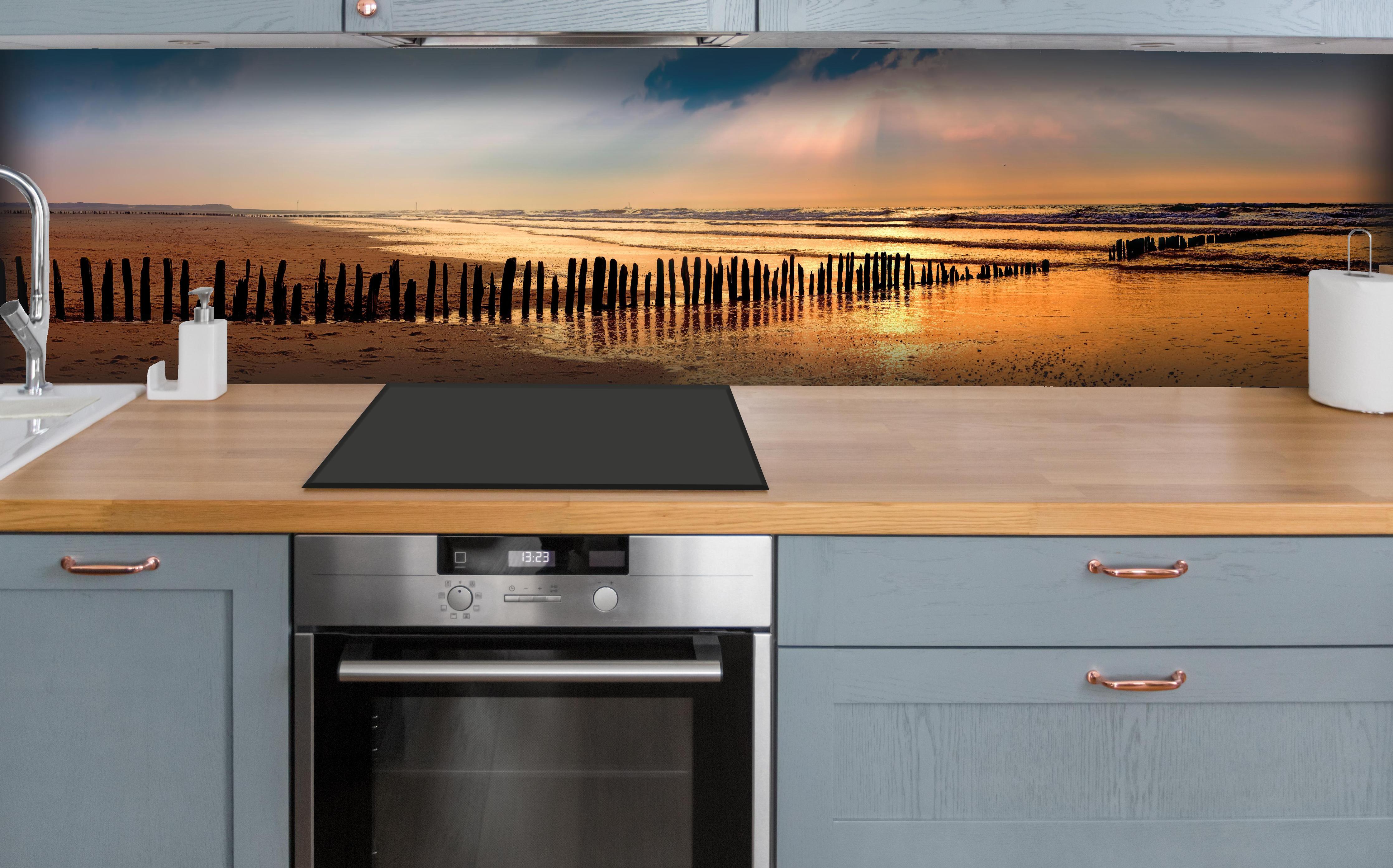 Küche - Faszinierender Sonnenuntergang über dem ruhigen Meer hinter weißen Hochglanz-Küchenregalen und schwarzem Wasserhahn
