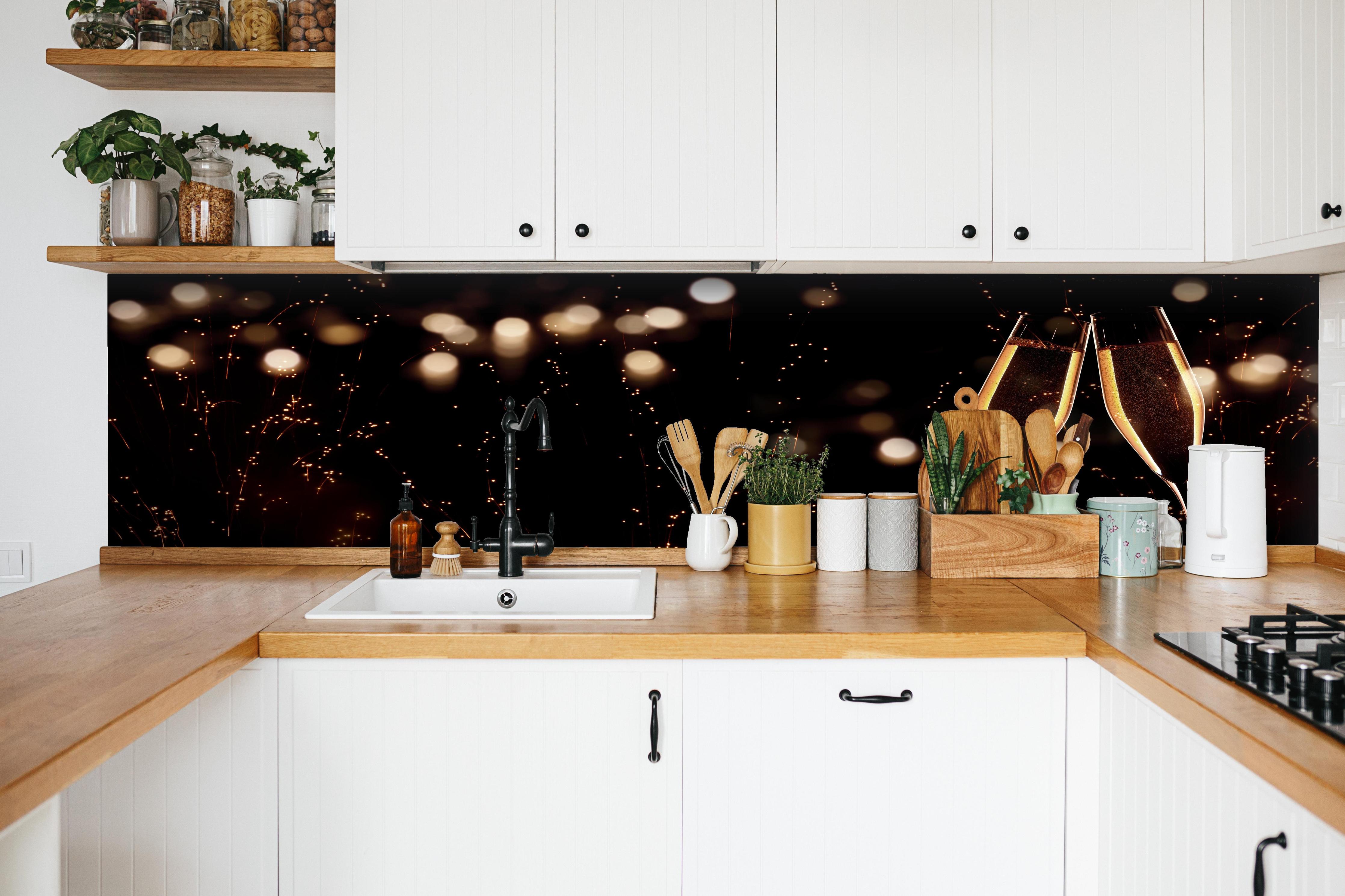 Küche - Feierlicher Champagner-Clink bei Jahreswechsel hinter weißen Hochglanz-Küchenregalen und schwarzem Wasserhahn