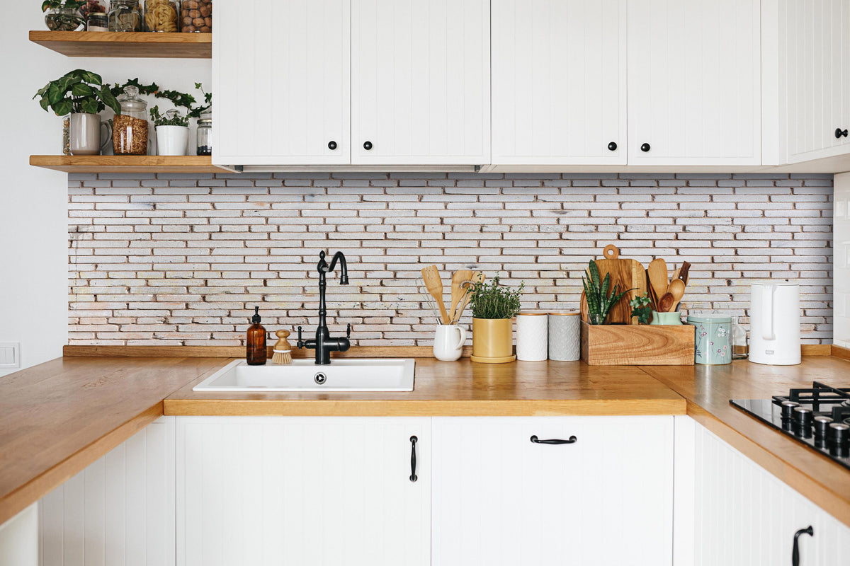 Küche - Feine weiße Ziegelmauer Struktur hinter weißen Hochglanz-Küchenregalen und schwarzem Wasserhahn