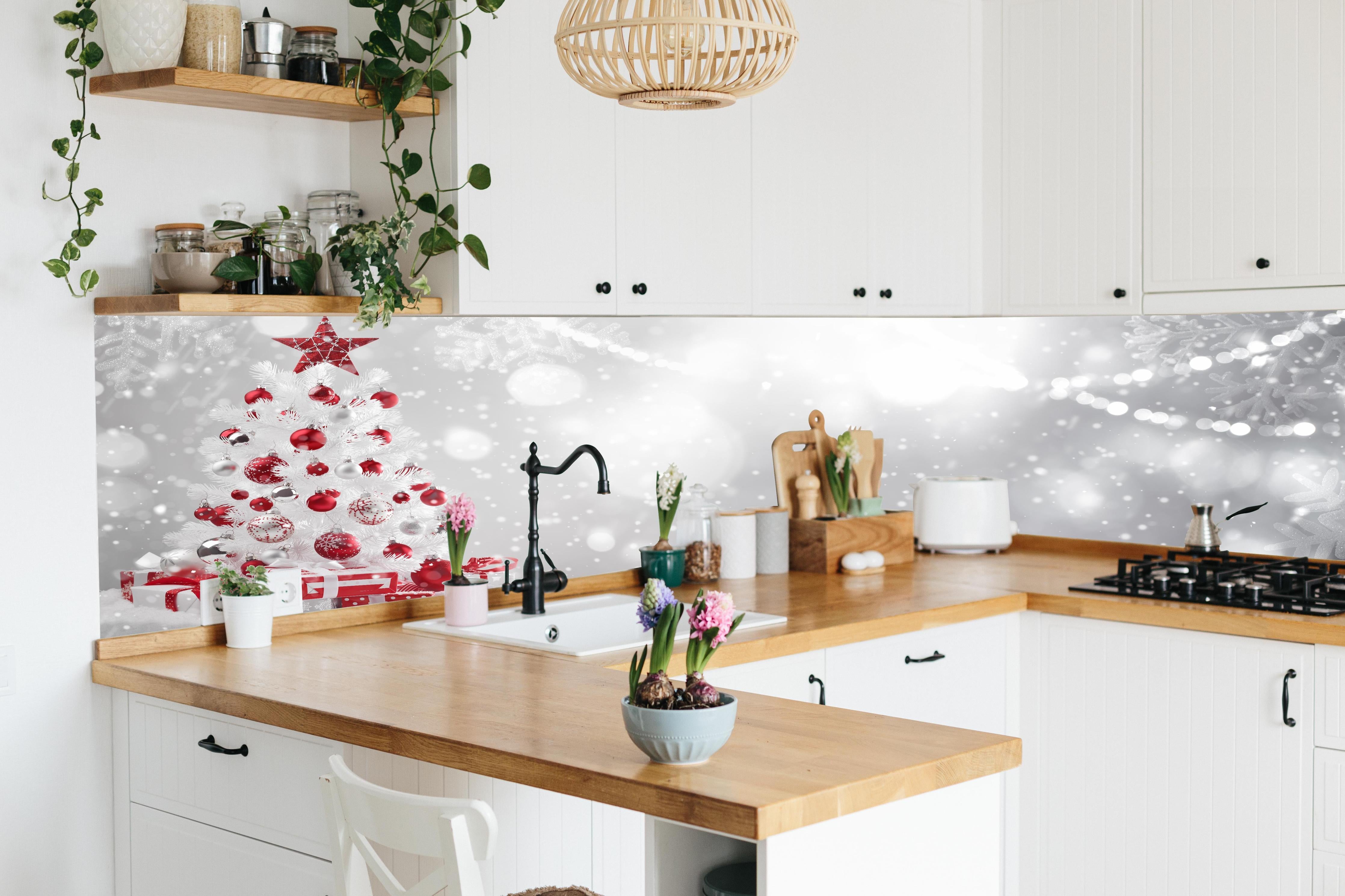 Küche - Festlicher Weihnachtsbaum mit roten Akzenten hinter weißen Hochglanz-Küchenregalen und schwarzem Wasserhahn