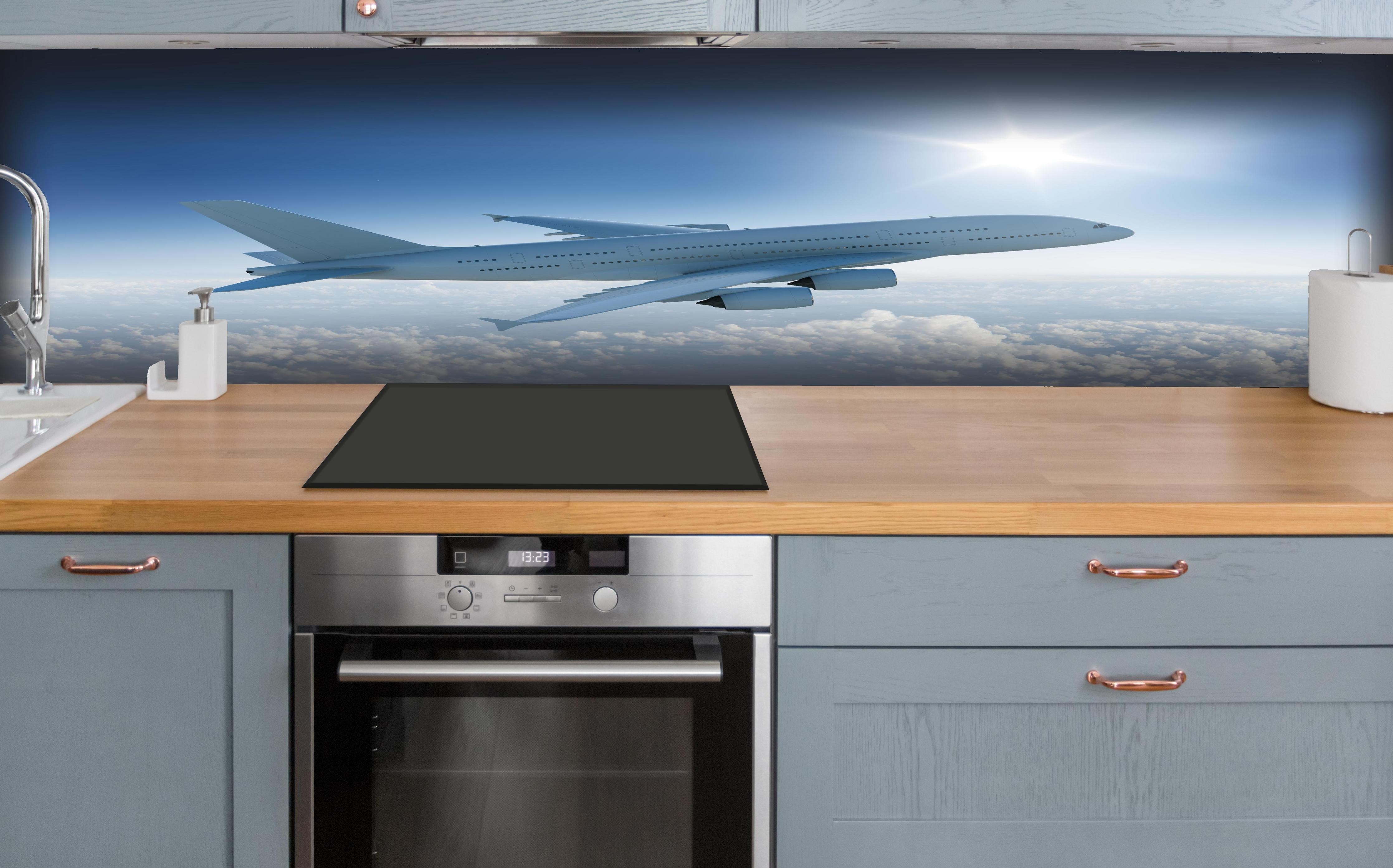 Küche - Flugzeug über weißen Wolken hinter weißen Hochglanz-Küchenregalen und schwarzem Wasserhahn