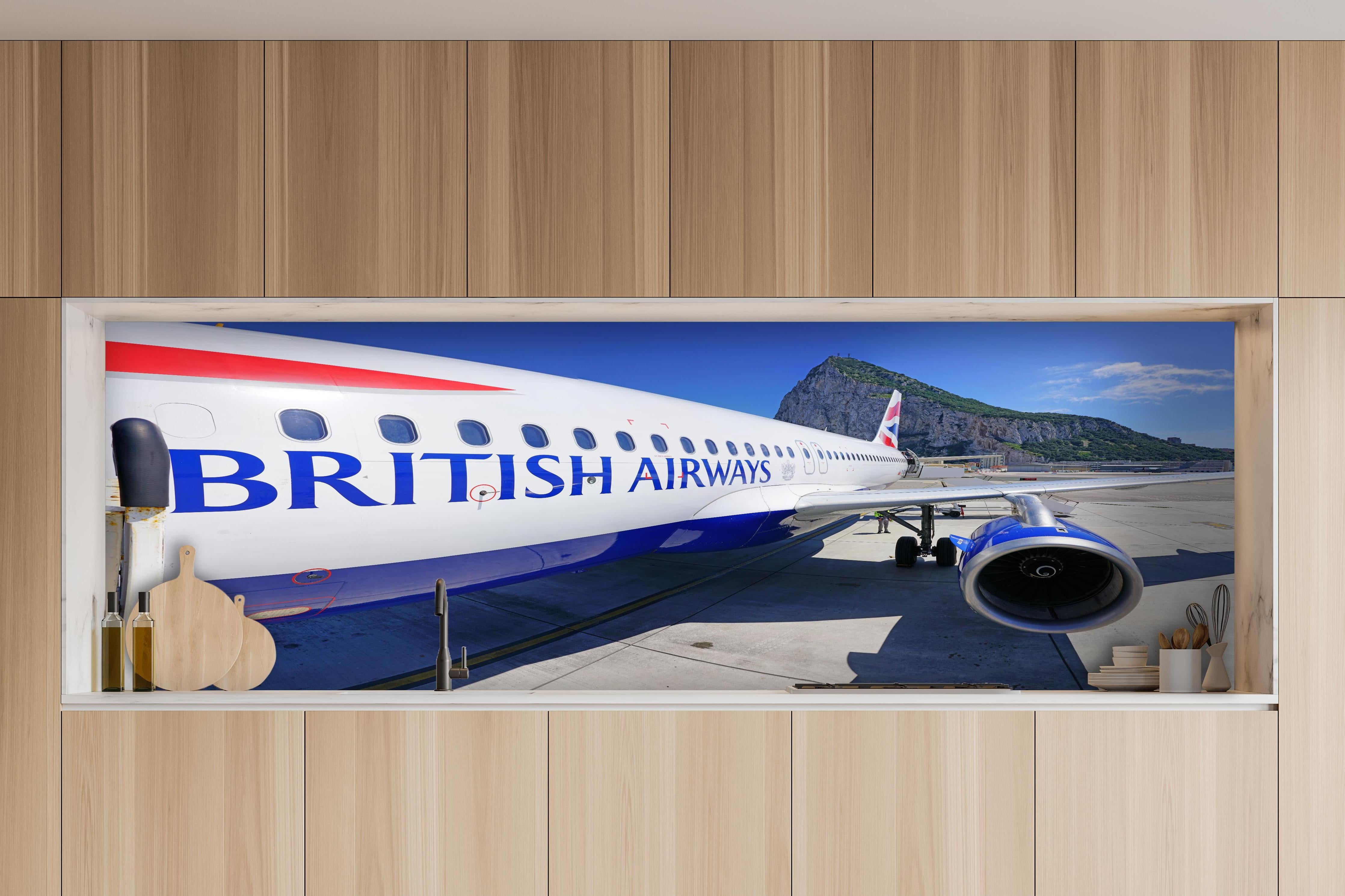 Küche - Flugzeug von British Airways hinter weißen Hochglanz-Küchenregalen und schwarzem Wasserhahn