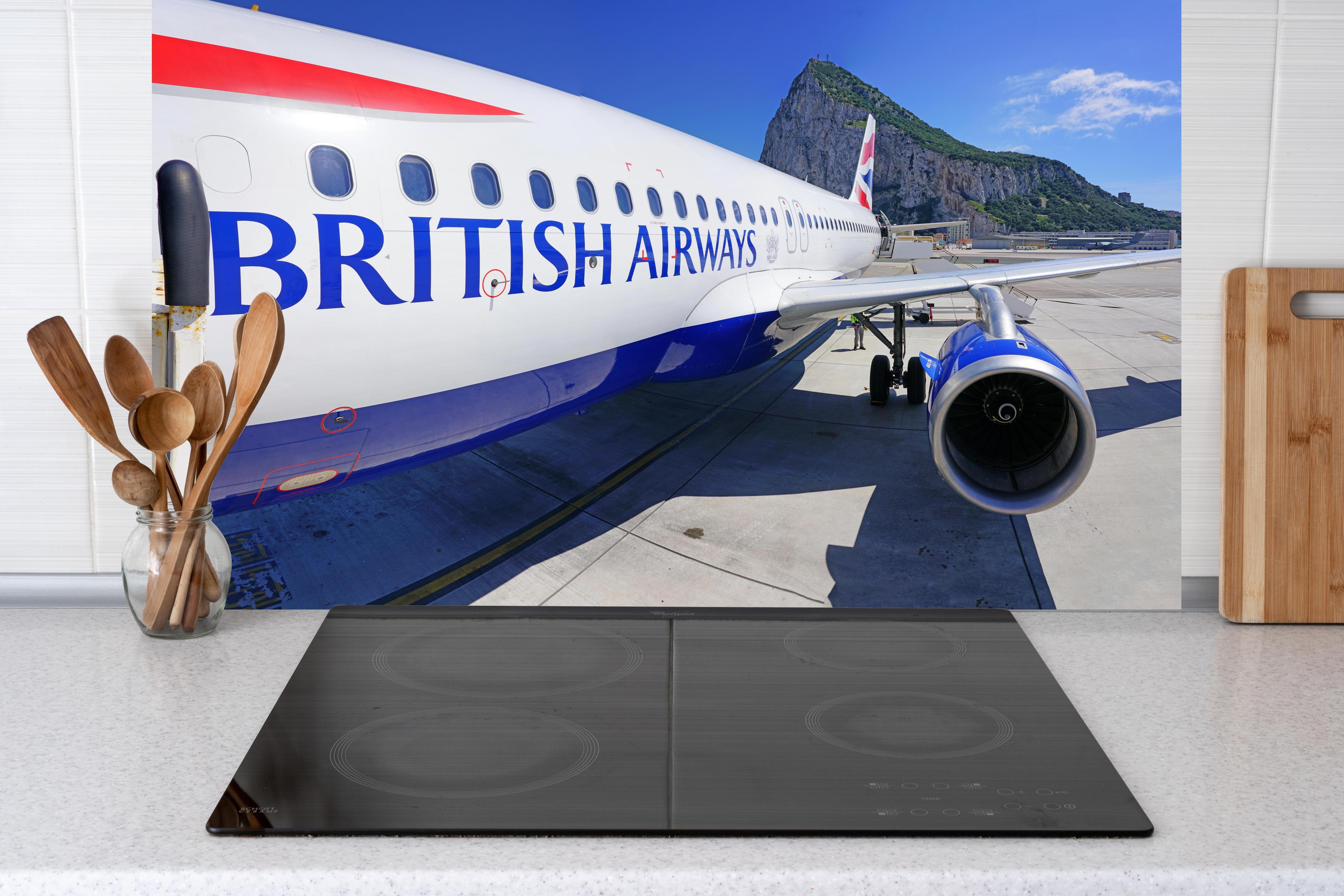 Küche - Flugzeug von British Airways hinter weißen Hochglanz-Küchenregalen und schwarzem Wasserhahn
