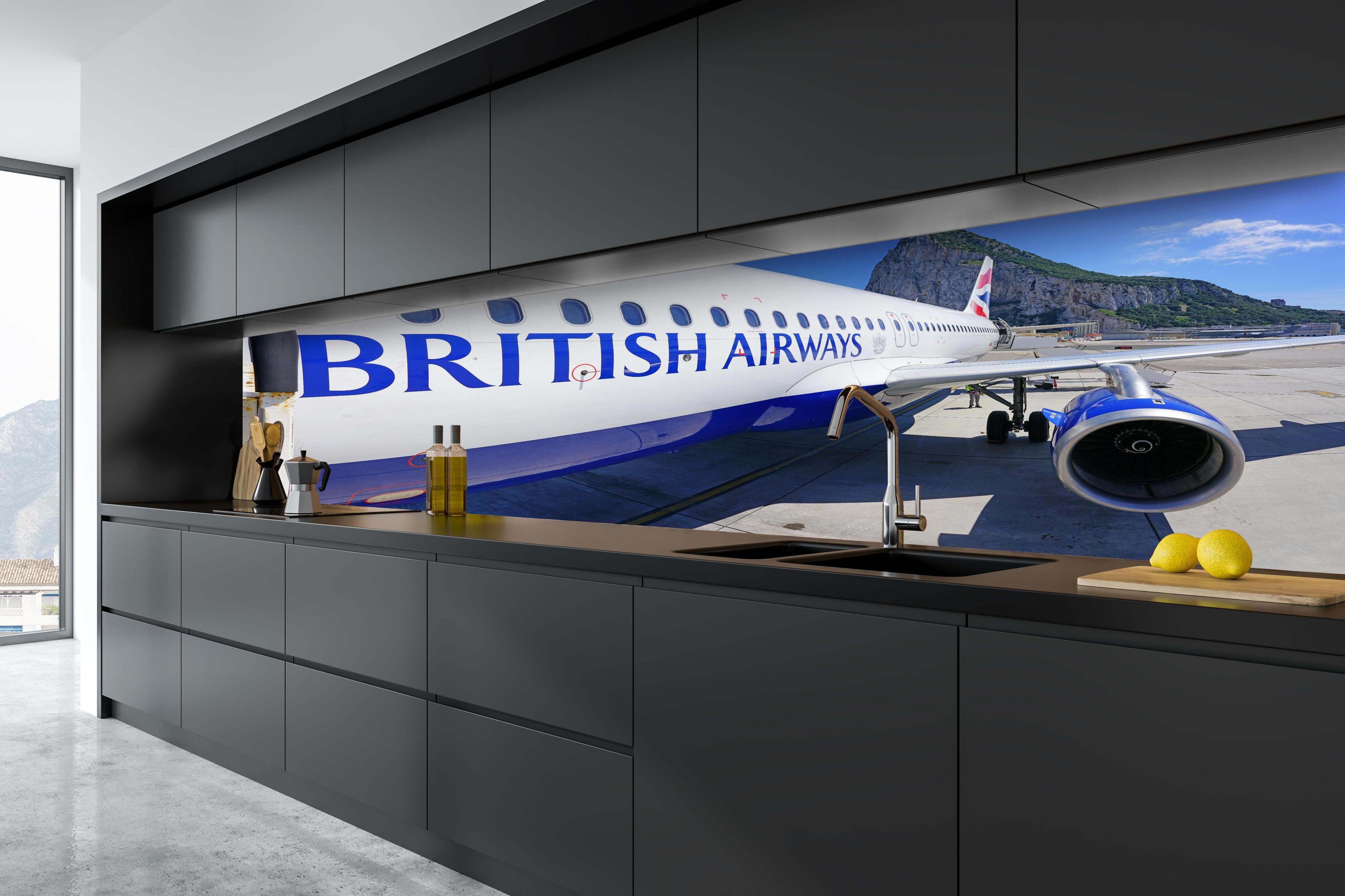 Küche - Flugzeug von British Airways hinter weißen Hochglanz-Küchenregalen und schwarzem Wasserhahn