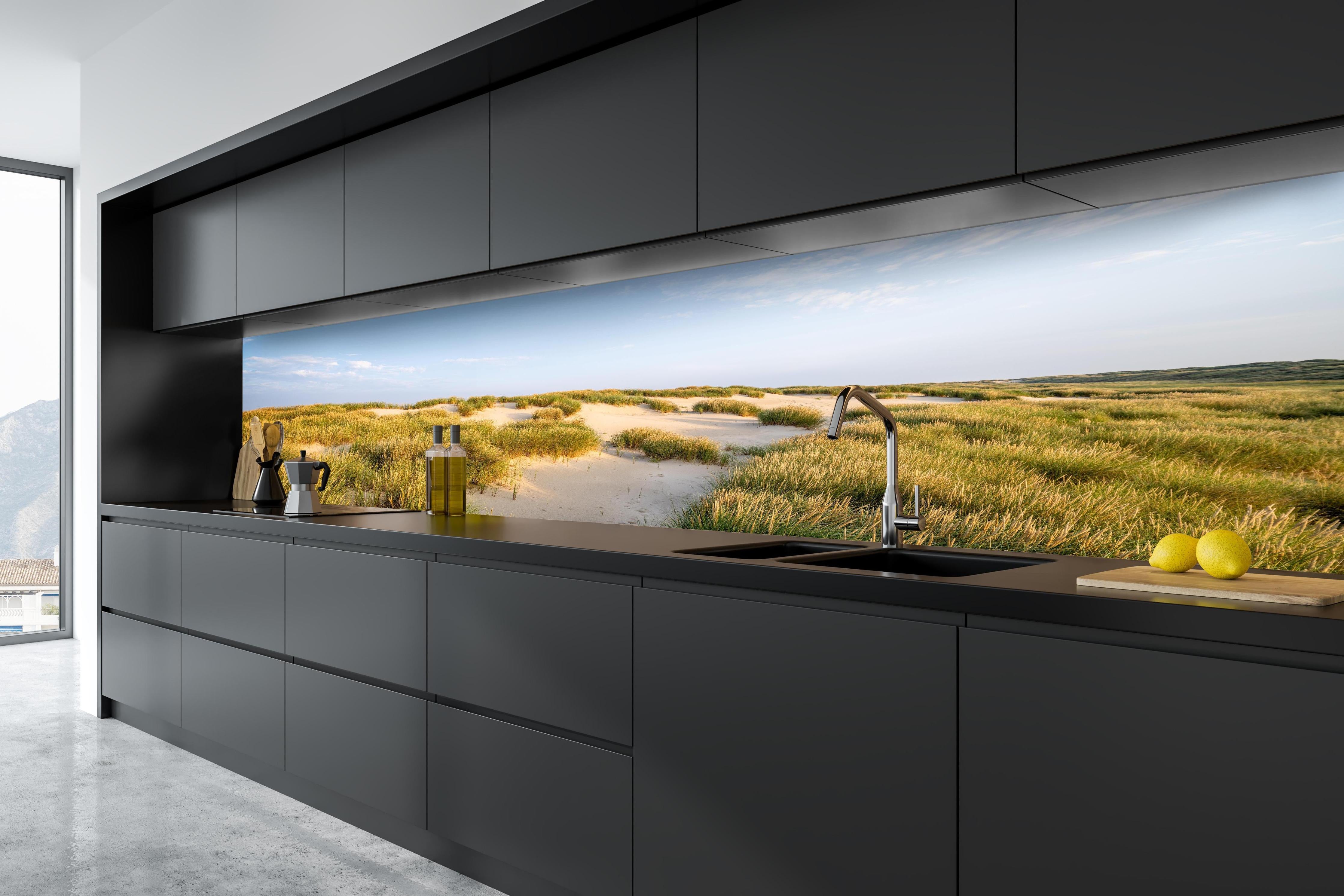 Küche - Friedliche Dünenlandschaft mit leuchtendem Gras im warmen Sonnenlicht hinter weißen Hochglanz-Küchenregalen und schwarzem Wasserhahn