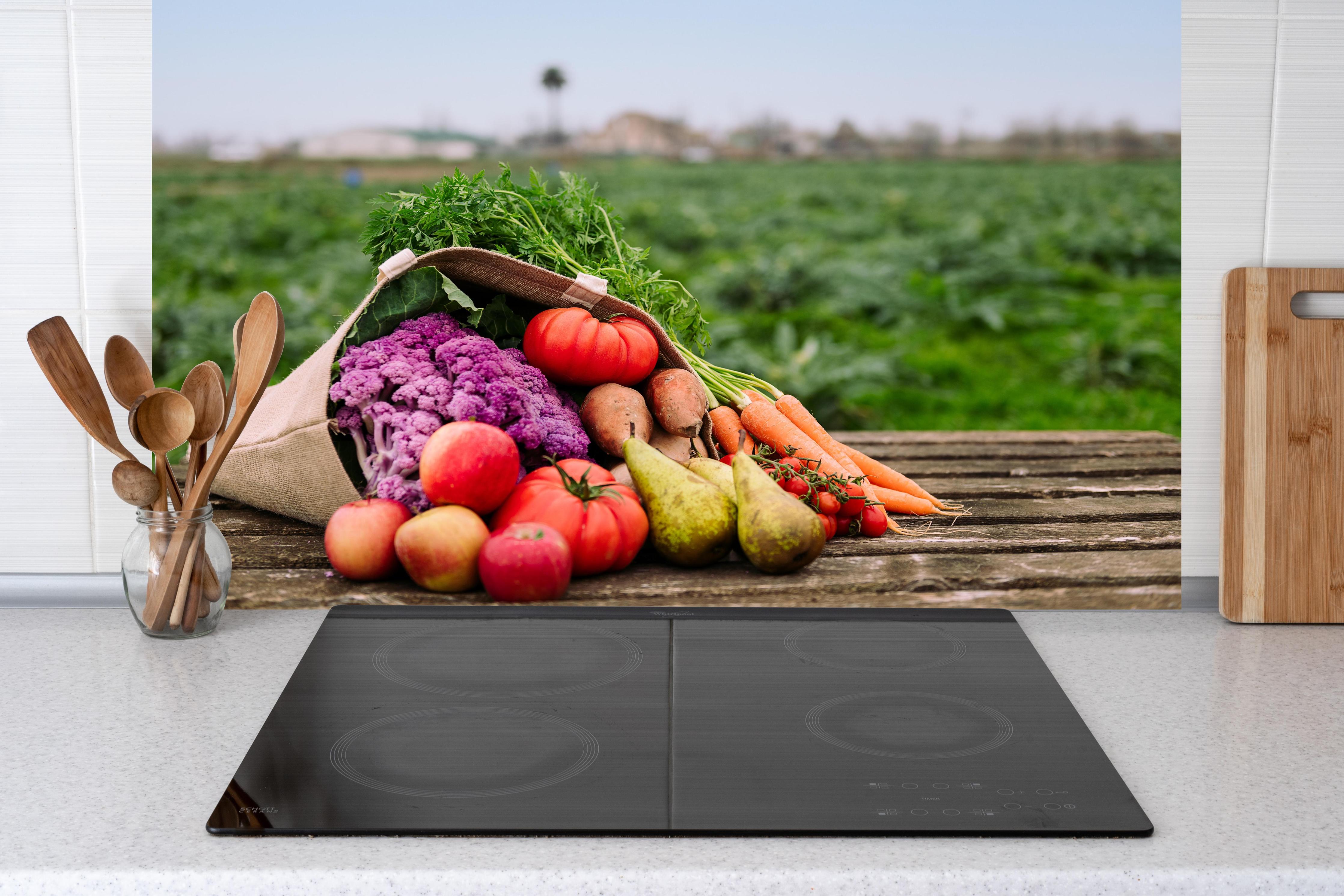 Küche - Frische Bio-Ernte in Bunt hinter weißen Hochglanz-Küchenregalen und schwarzem Wasserhahn