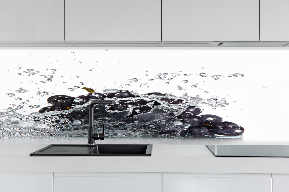 Küche - Frische Trauben im Wasser Splash hinter weißen Hochglanz-Küchenregalen und schwarzem Wasserhahn