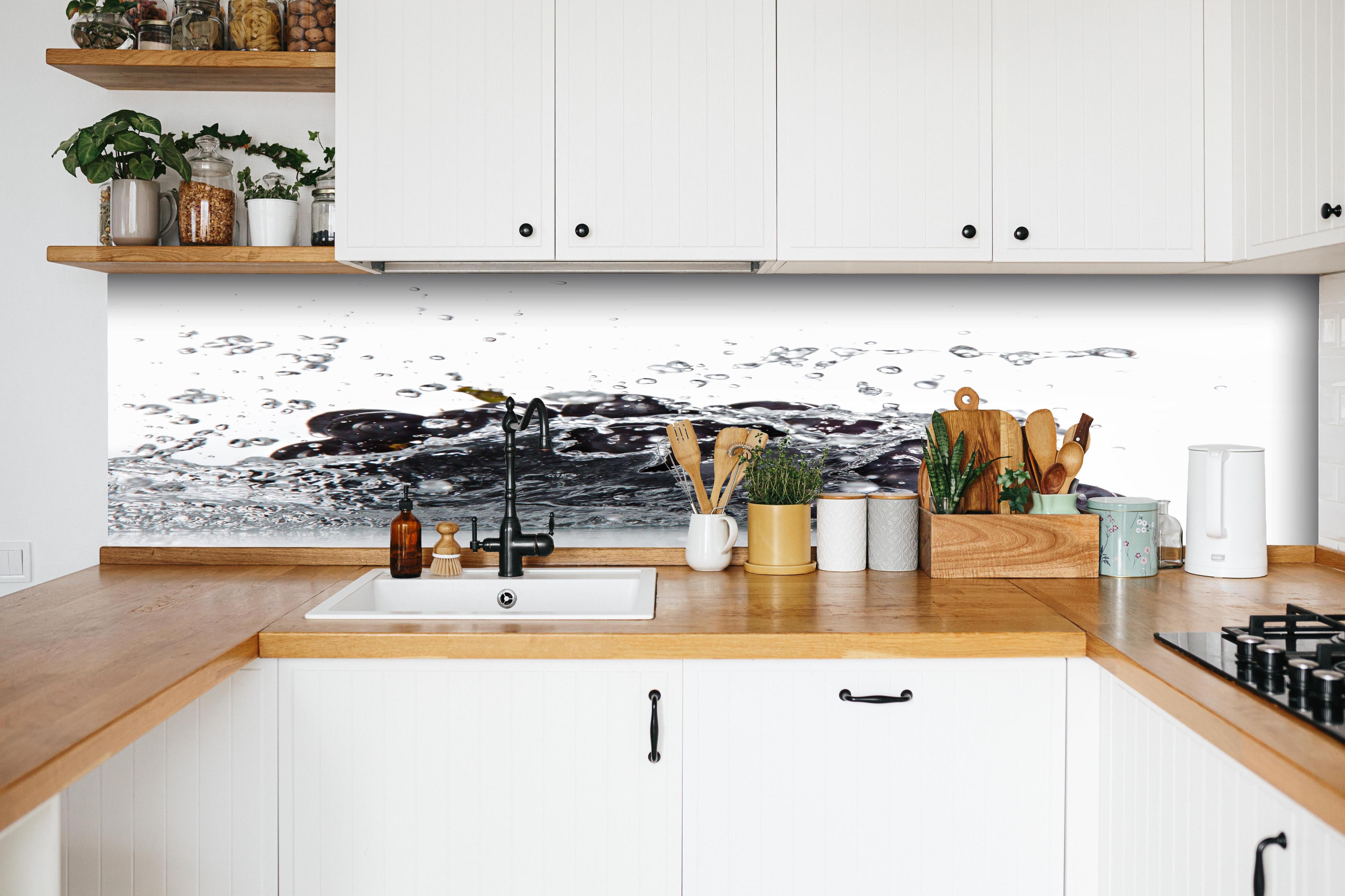 Küche - Frische Trauben im Wasser Splash hinter weißen Hochglanz-Küchenregalen und schwarzem Wasserhahn