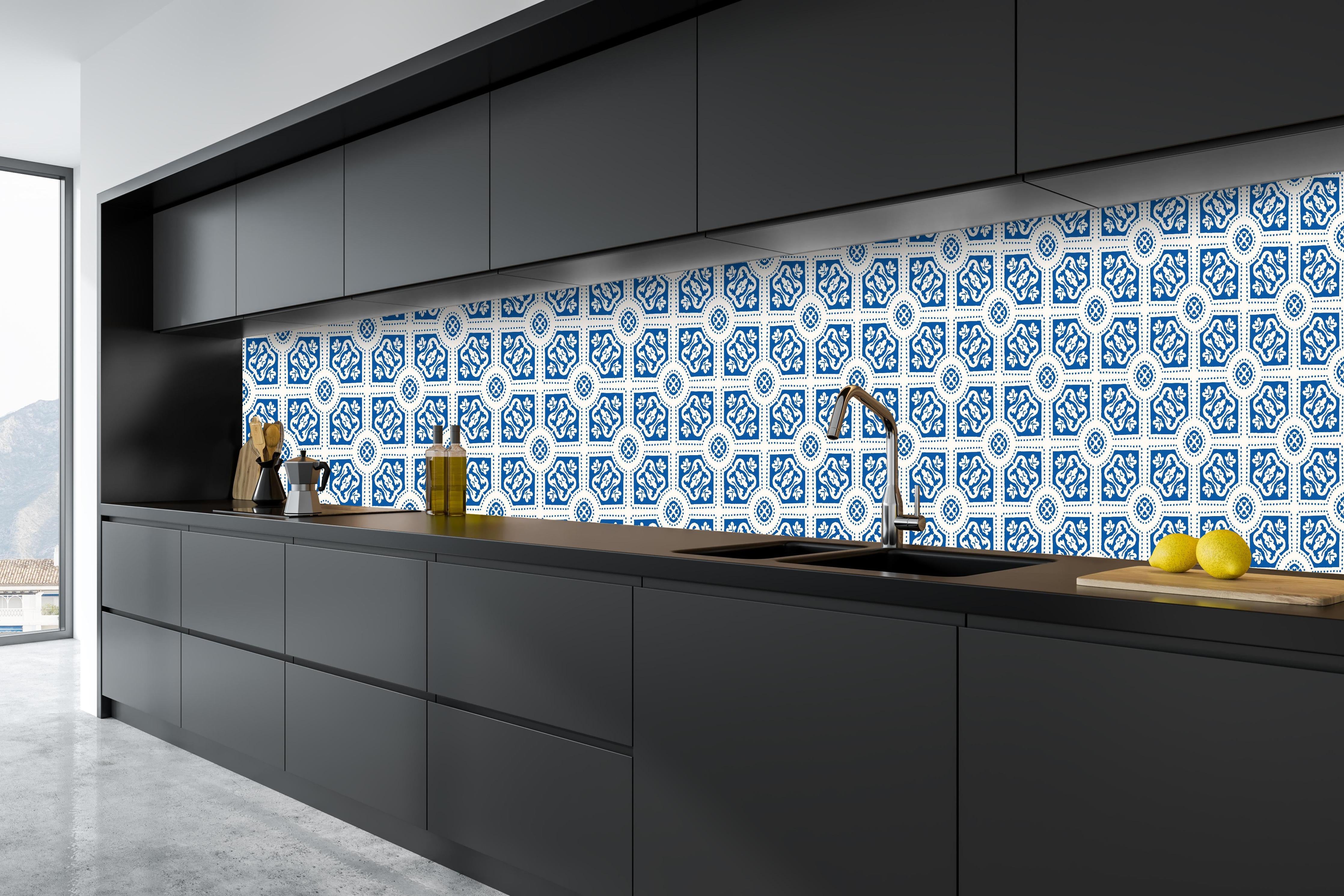 Küche - Geometrische Musterung in Blau und Weiß hinter weißen Hochglanz-Küchenregalen und schwarzem Wasserhahn