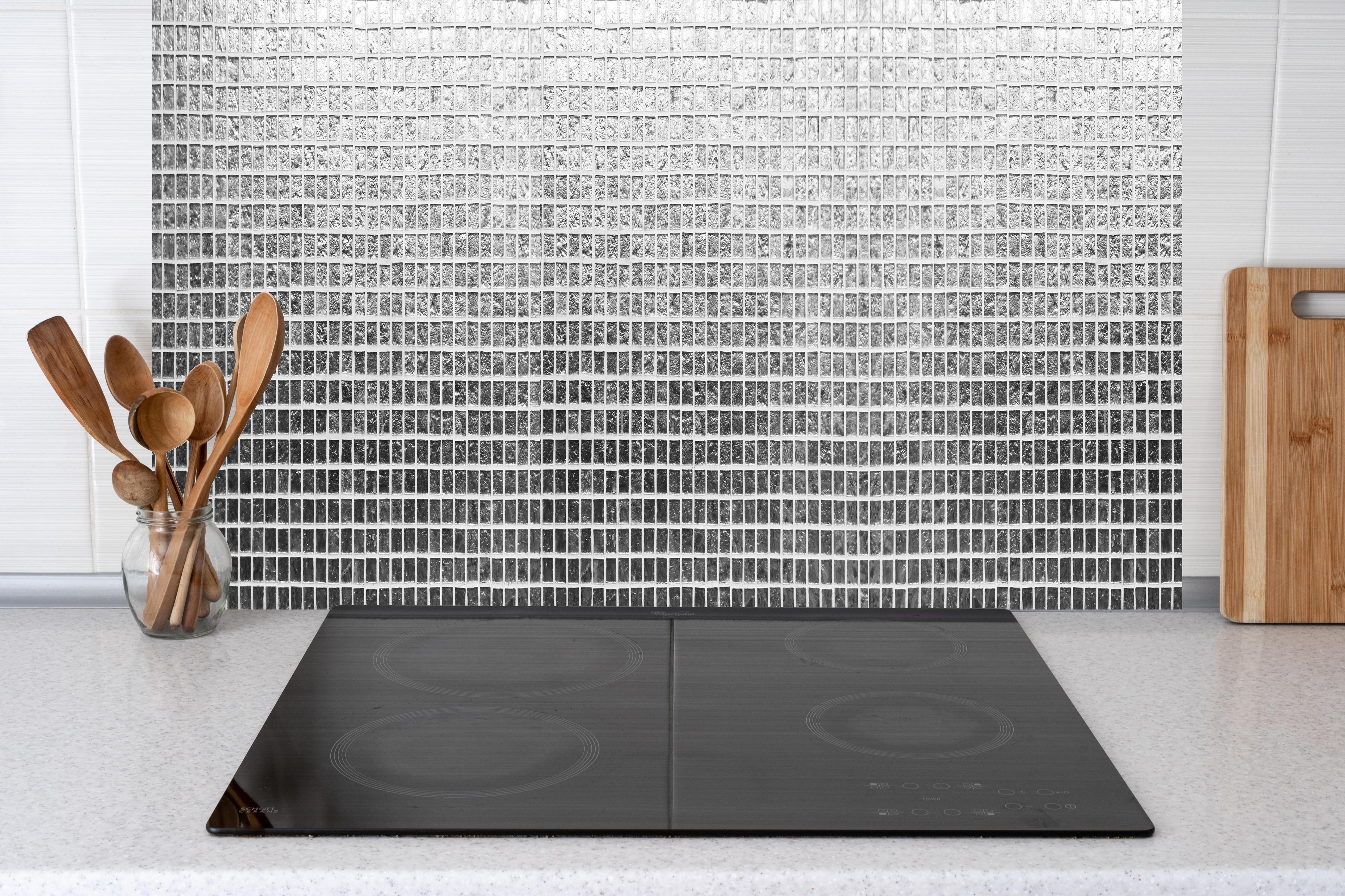 Küche - Glänzende Silberne Fliesen Textur Wand hinter weißen Hochglanz-Küchenregalen und schwarzem Wasserhahn