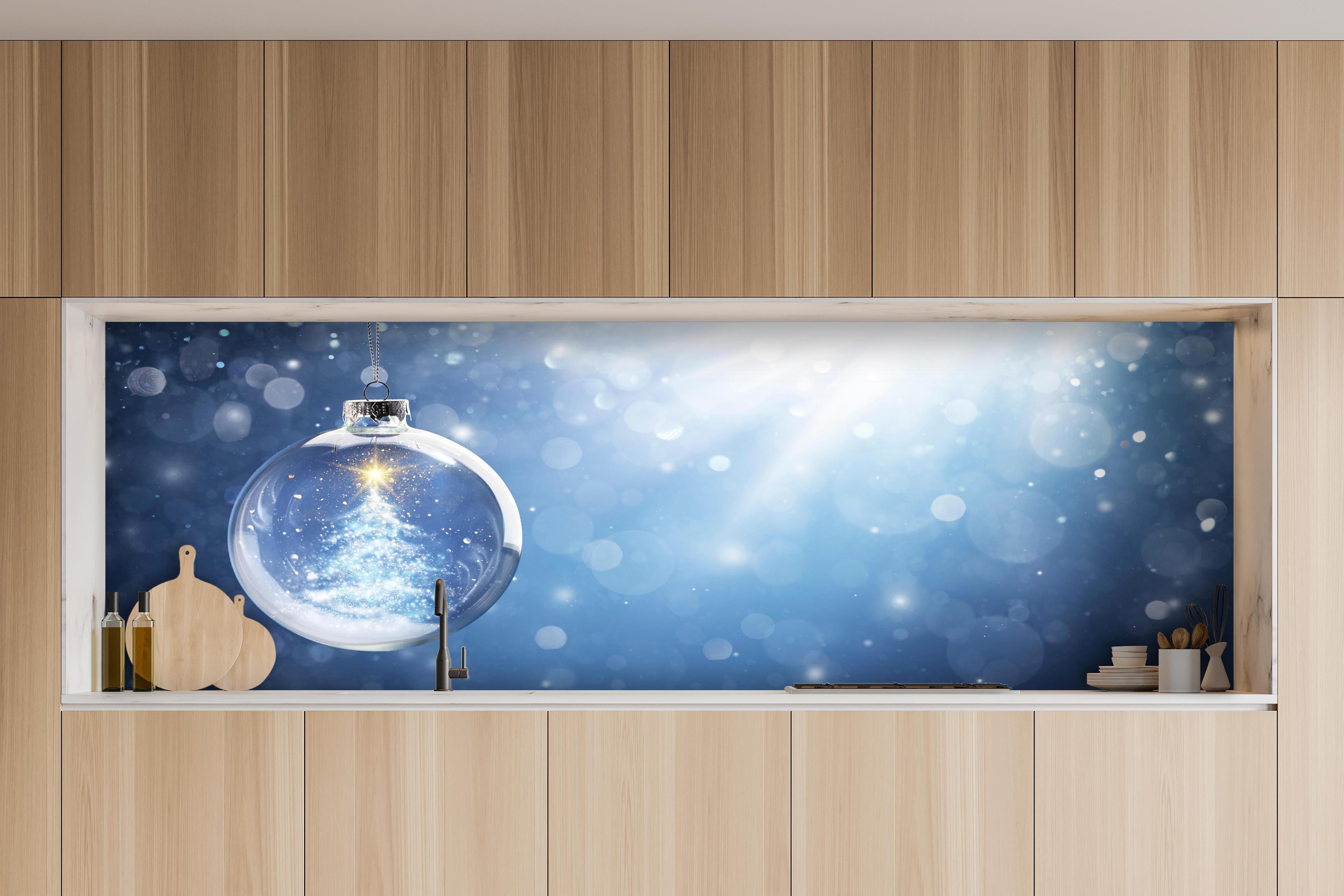 Küche - Glänzender Weihnachtsbaum in Schneekugel hinter weißen Hochglanz-Küchenregalen und schwarzem Wasserhahn