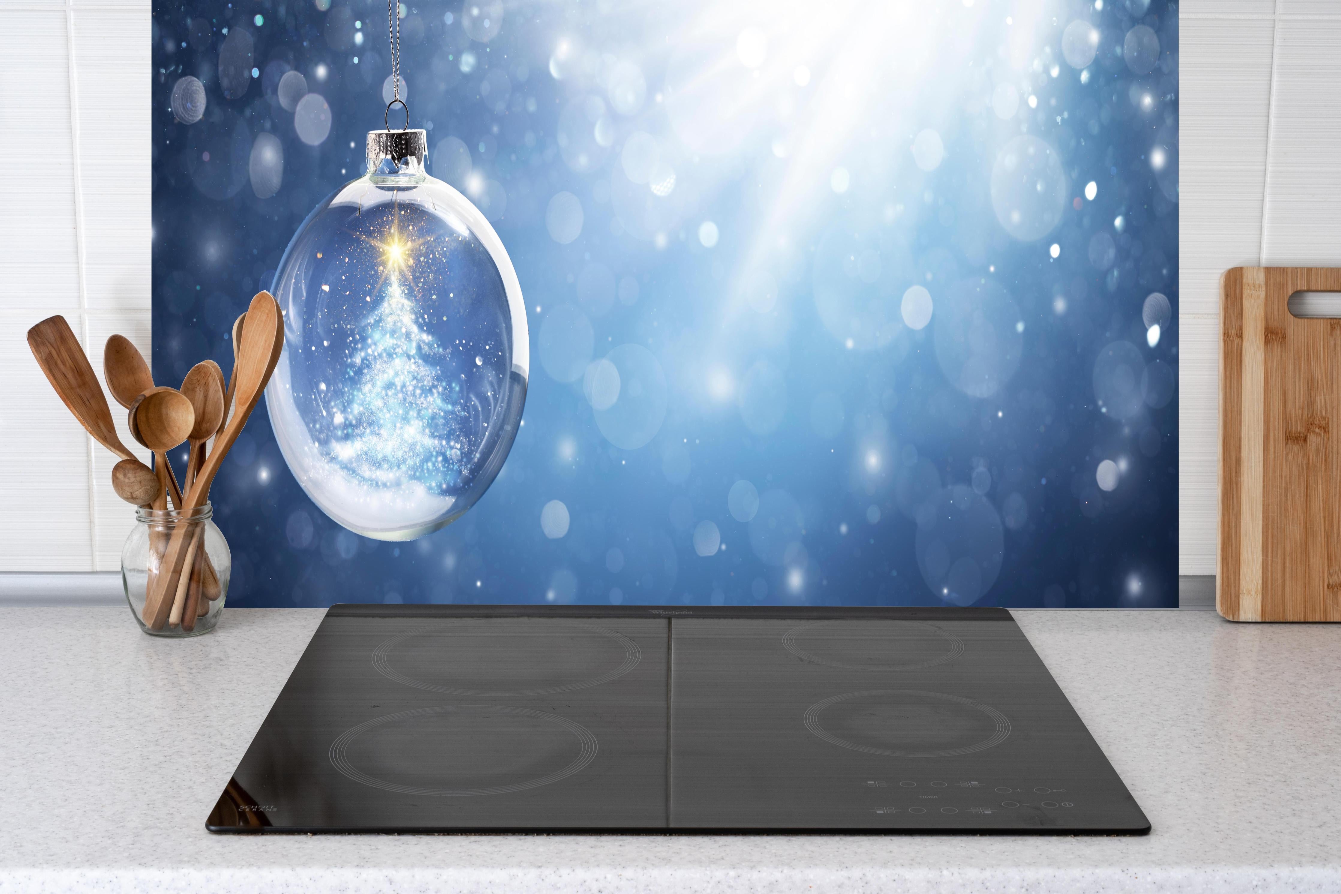 Küche - Glänzender Weihnachtsbaum in Schneekugel hinter weißen Hochglanz-Küchenregalen und schwarzem Wasserhahn