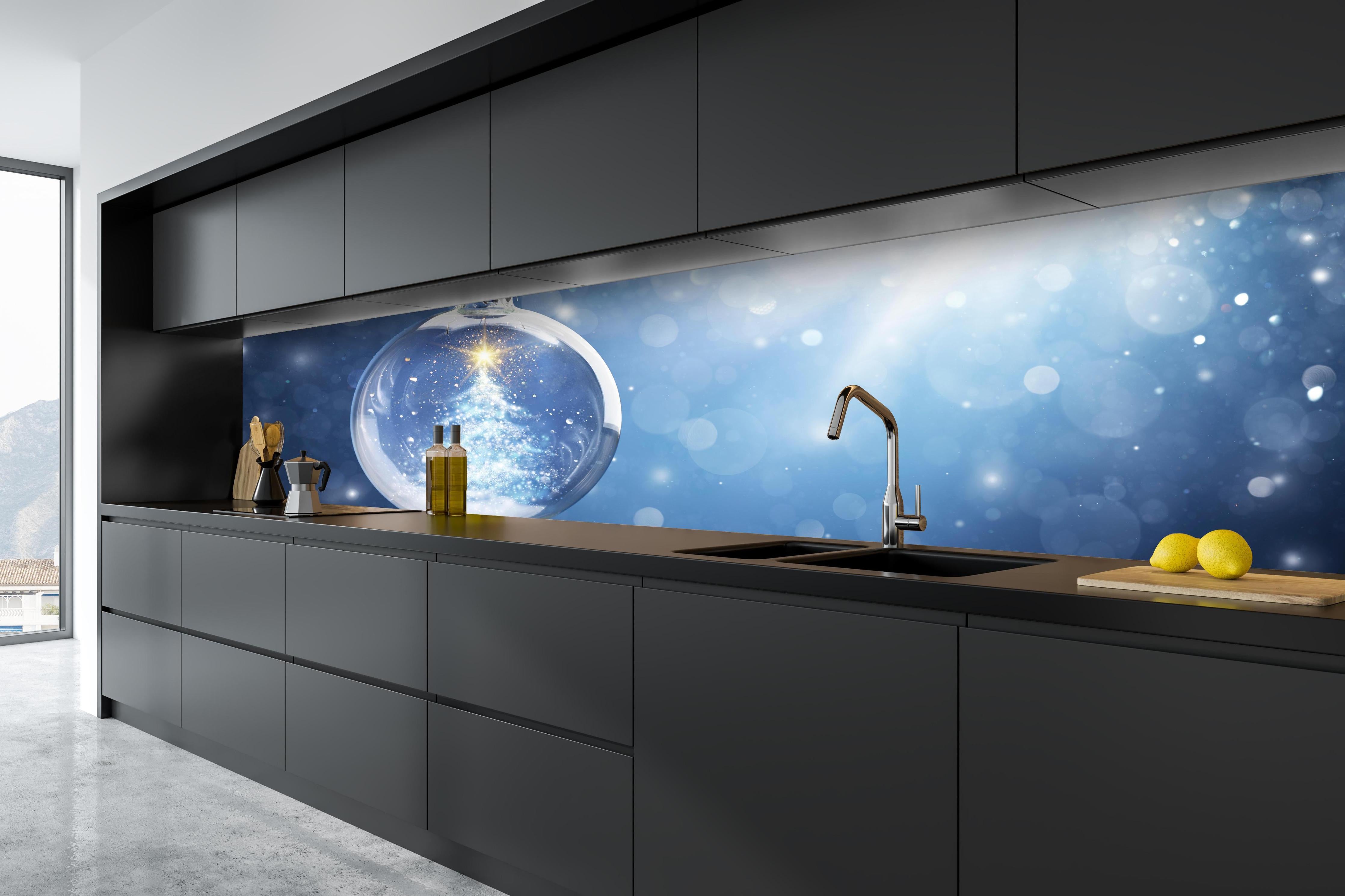 Küche - Glänzender Weihnachtsbaum in Schneekugel hinter weißen Hochglanz-Küchenregalen und schwarzem Wasserhahn