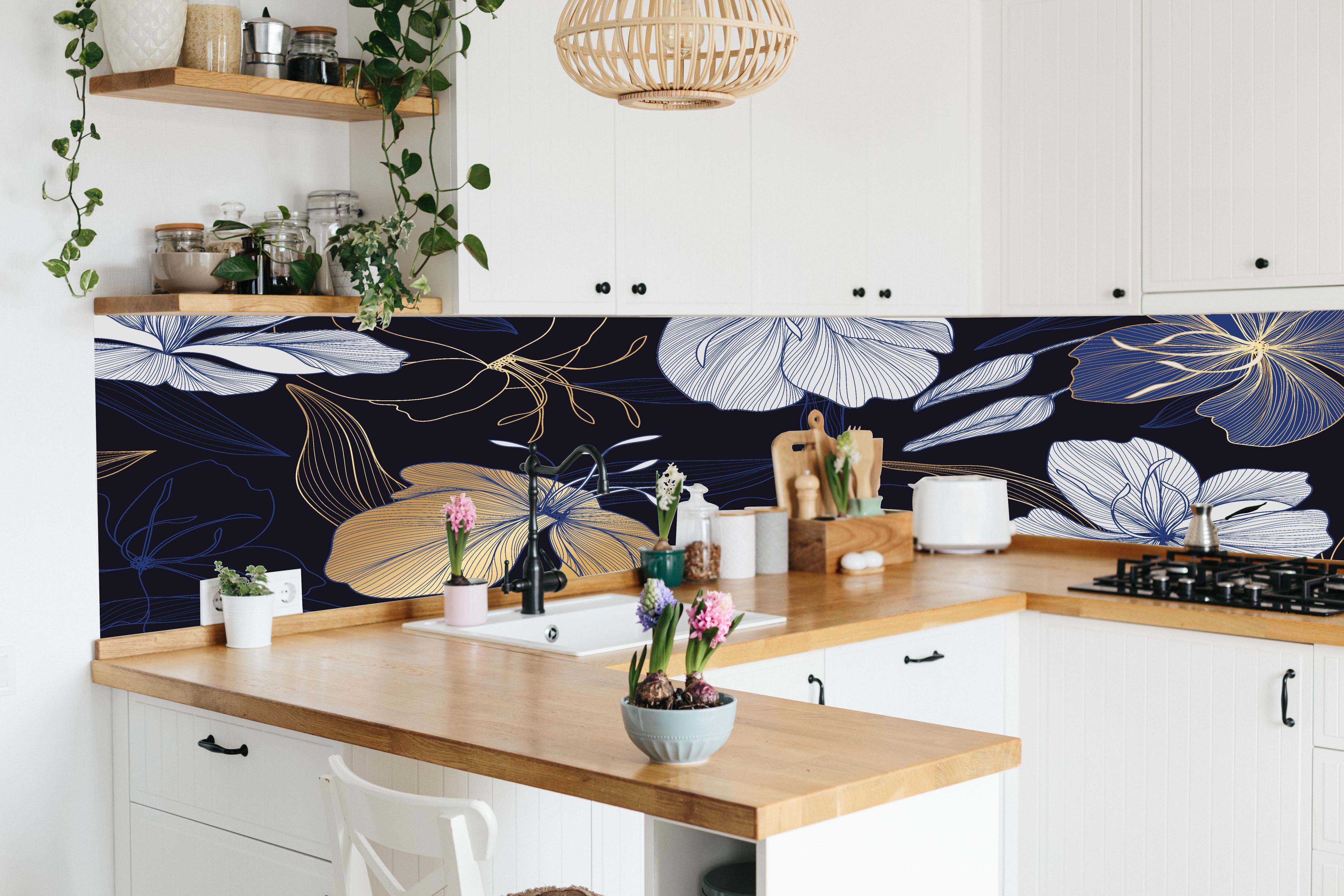 Küche - Goldene Blumenillustration auf Dunkelblau hinter weißen Hochglanz-Küchenregalen und schwarzem Wasserhahn