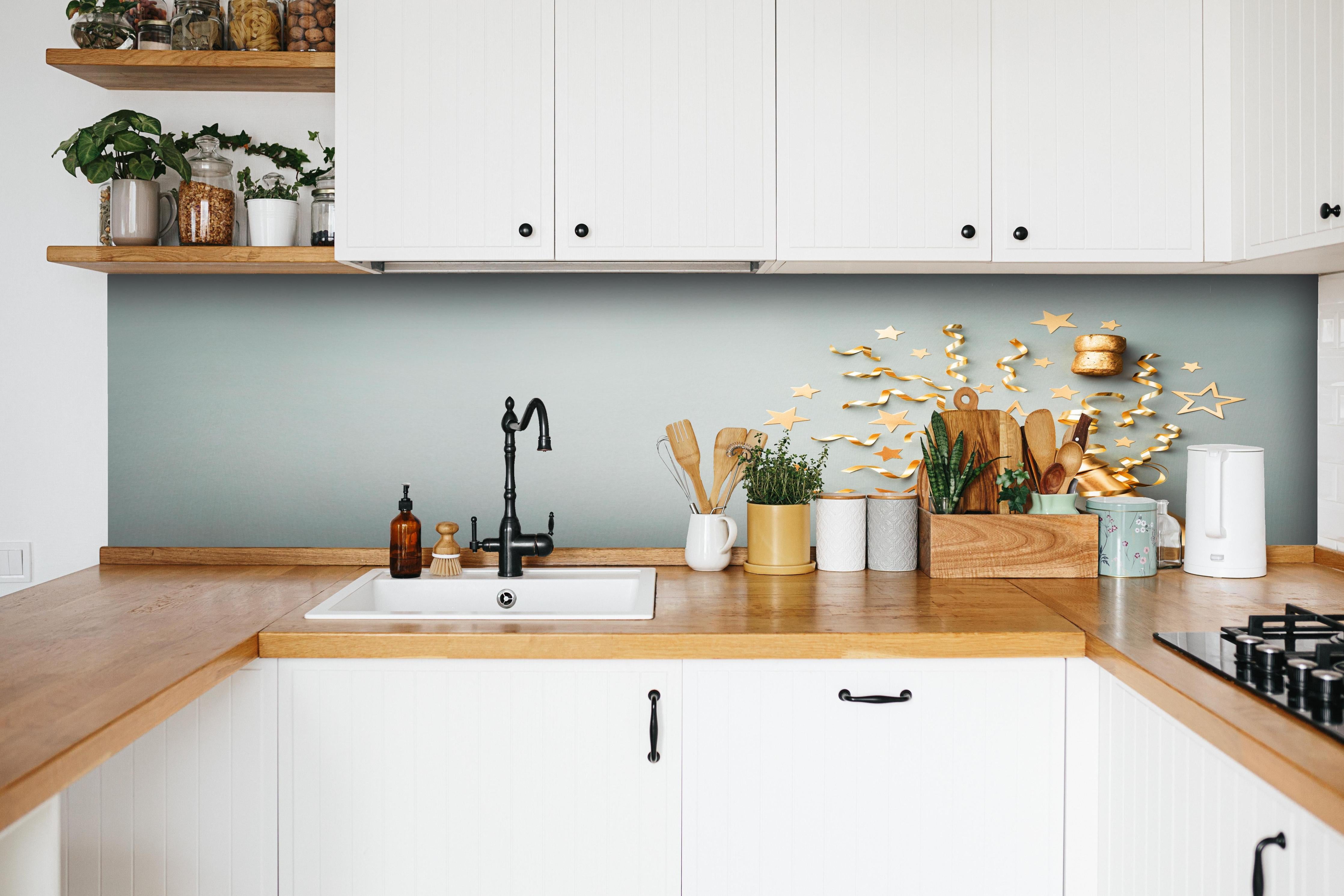 Küche - Goldene Champagnerflasche im Sylvester design hinter weißen Hochglanz-Küchenregalen und schwarzem Wasserhahn