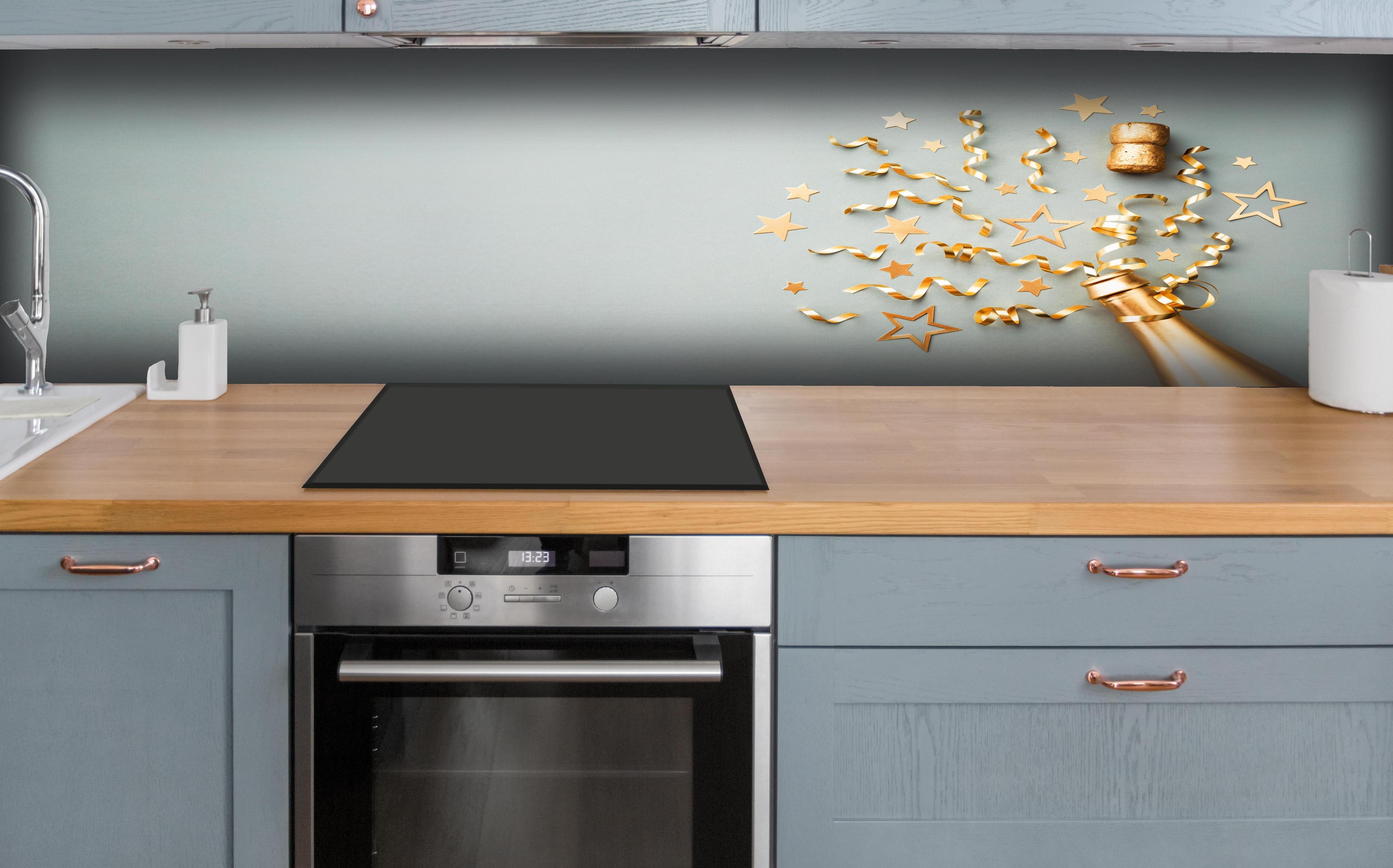 Küche - Goldene Champagnerflasche im Sylvester design hinter weißen Hochglanz-Küchenregalen und schwarzem Wasserhahn