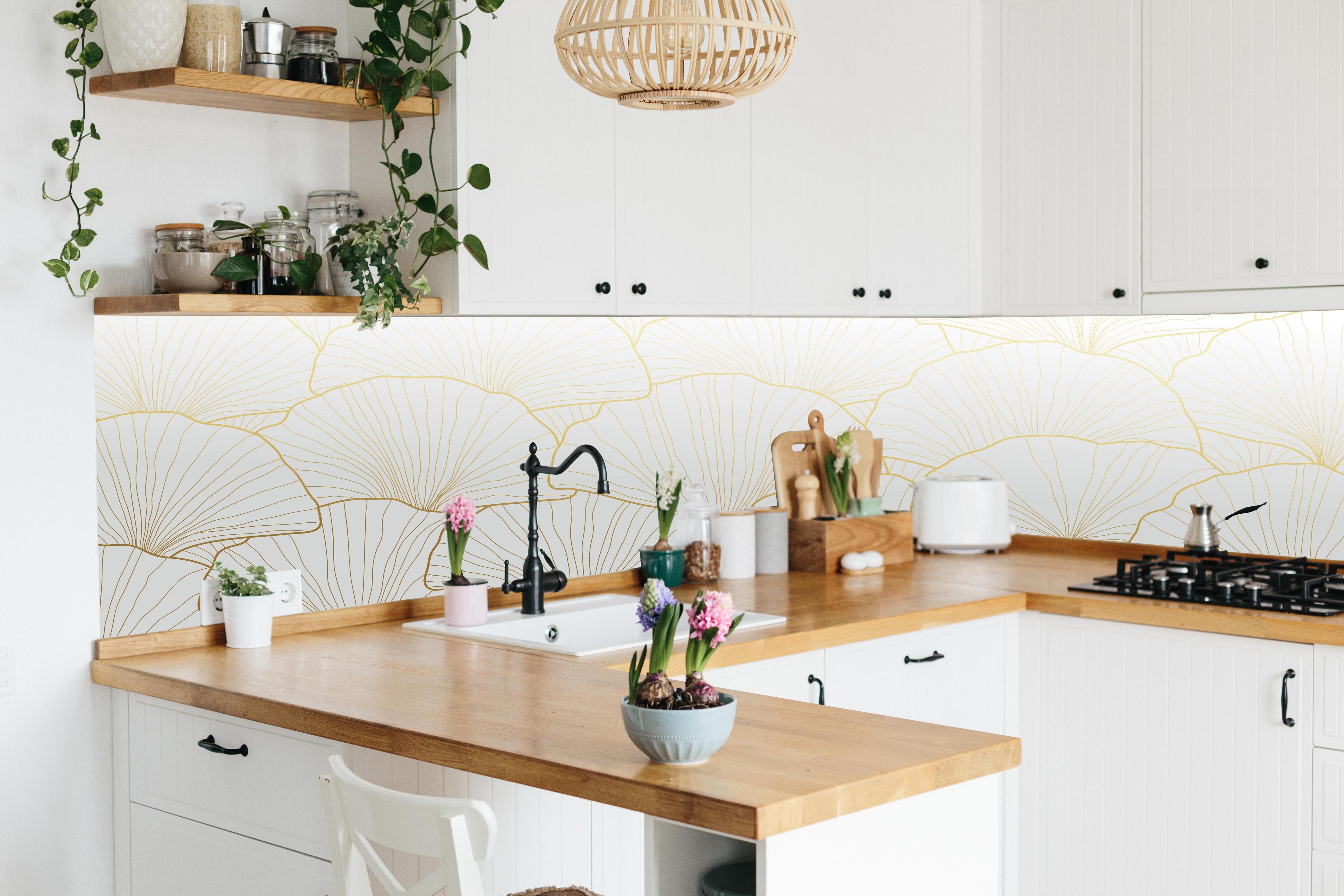 Küche - Goldene Ginkgo Blattstruktur hinter weißen Hochglanz-Küchenregalen und schwarzem Wasserhahn