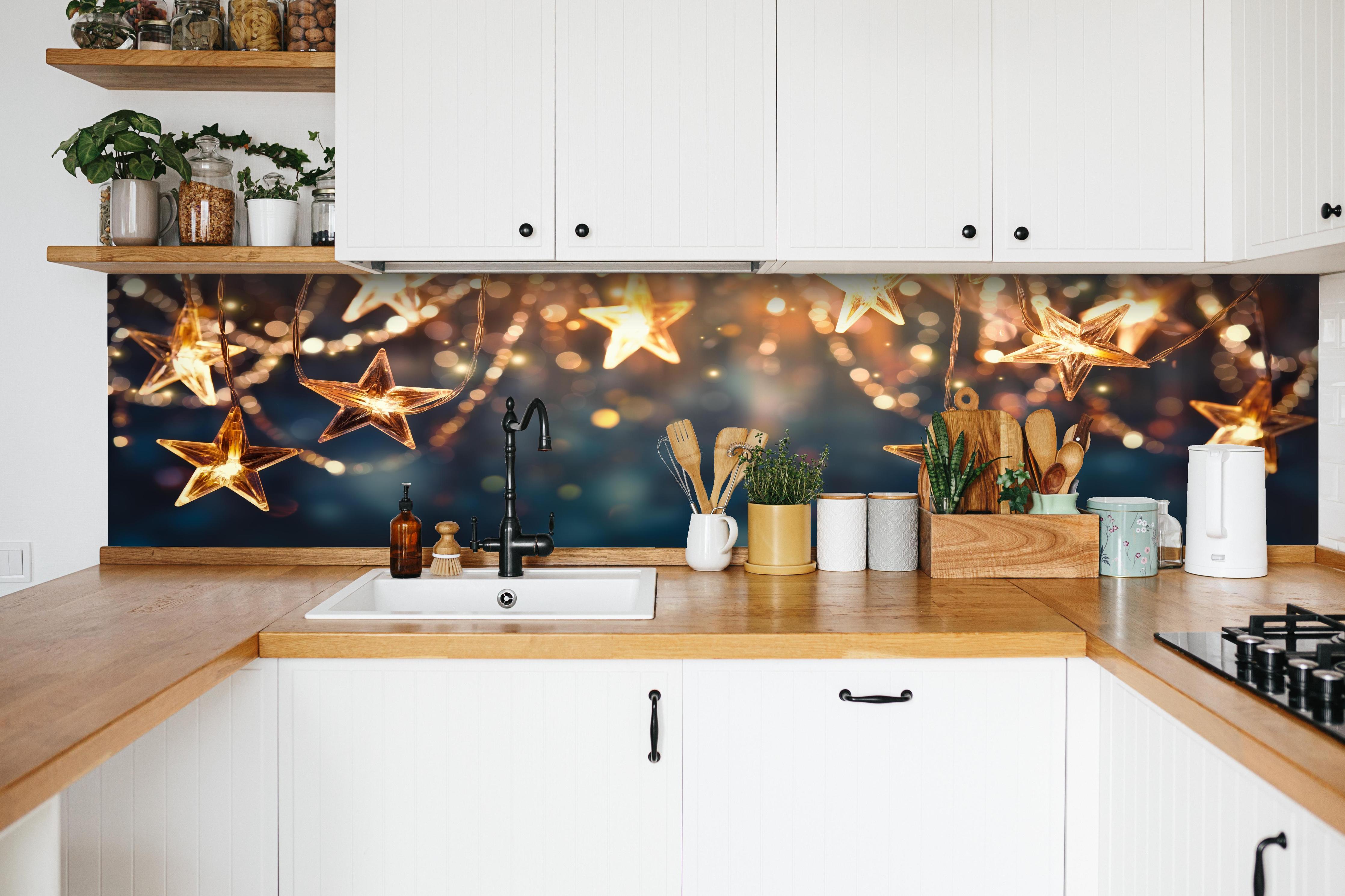 Küche - Goldene Sternen Lichterkette hinter weißen Hochglanz-Küchenregalen und schwarzem Wasserhahn