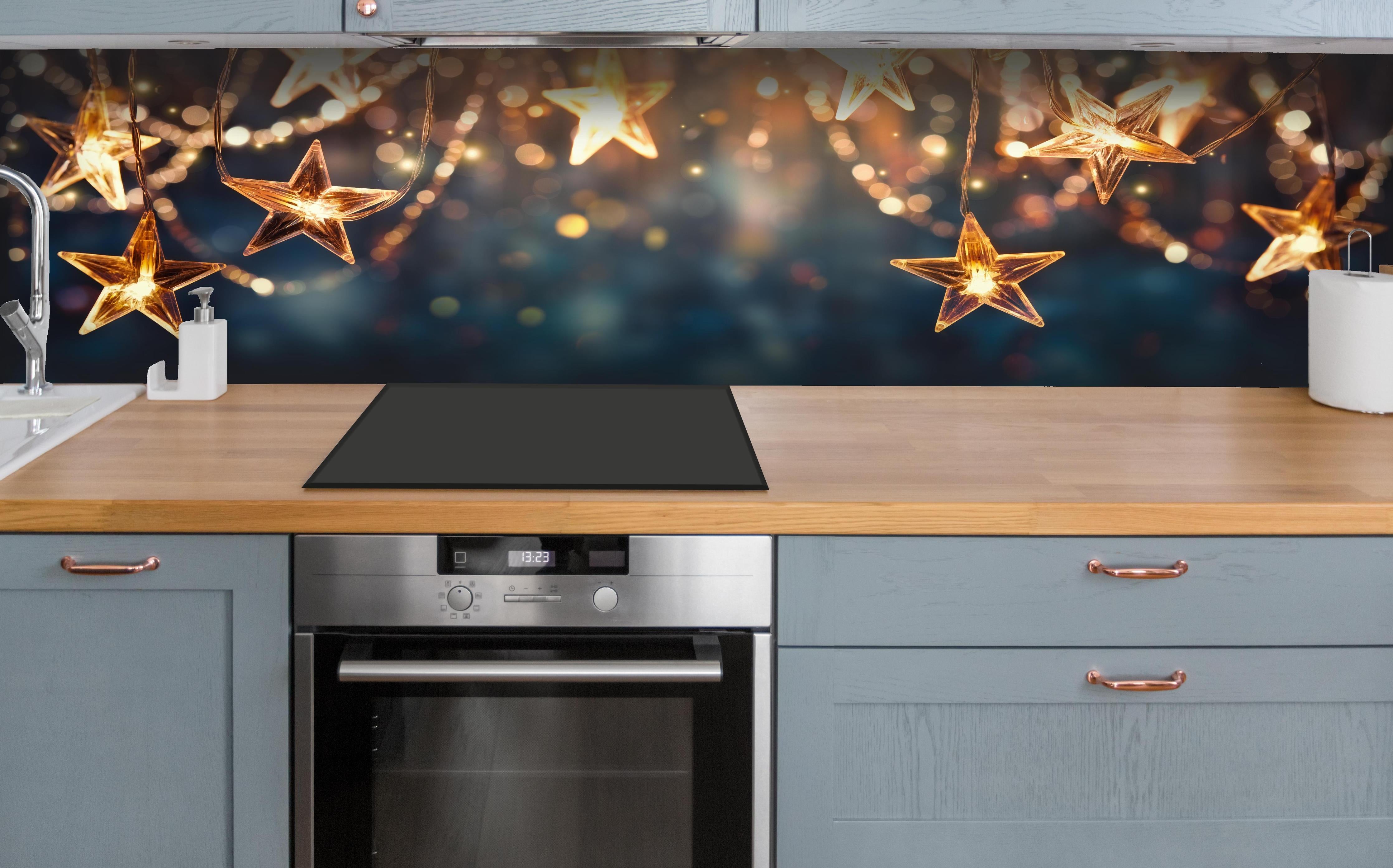 Küche - Goldene Sternen Lichterkette hinter weißen Hochglanz-Küchenregalen und schwarzem Wasserhahn