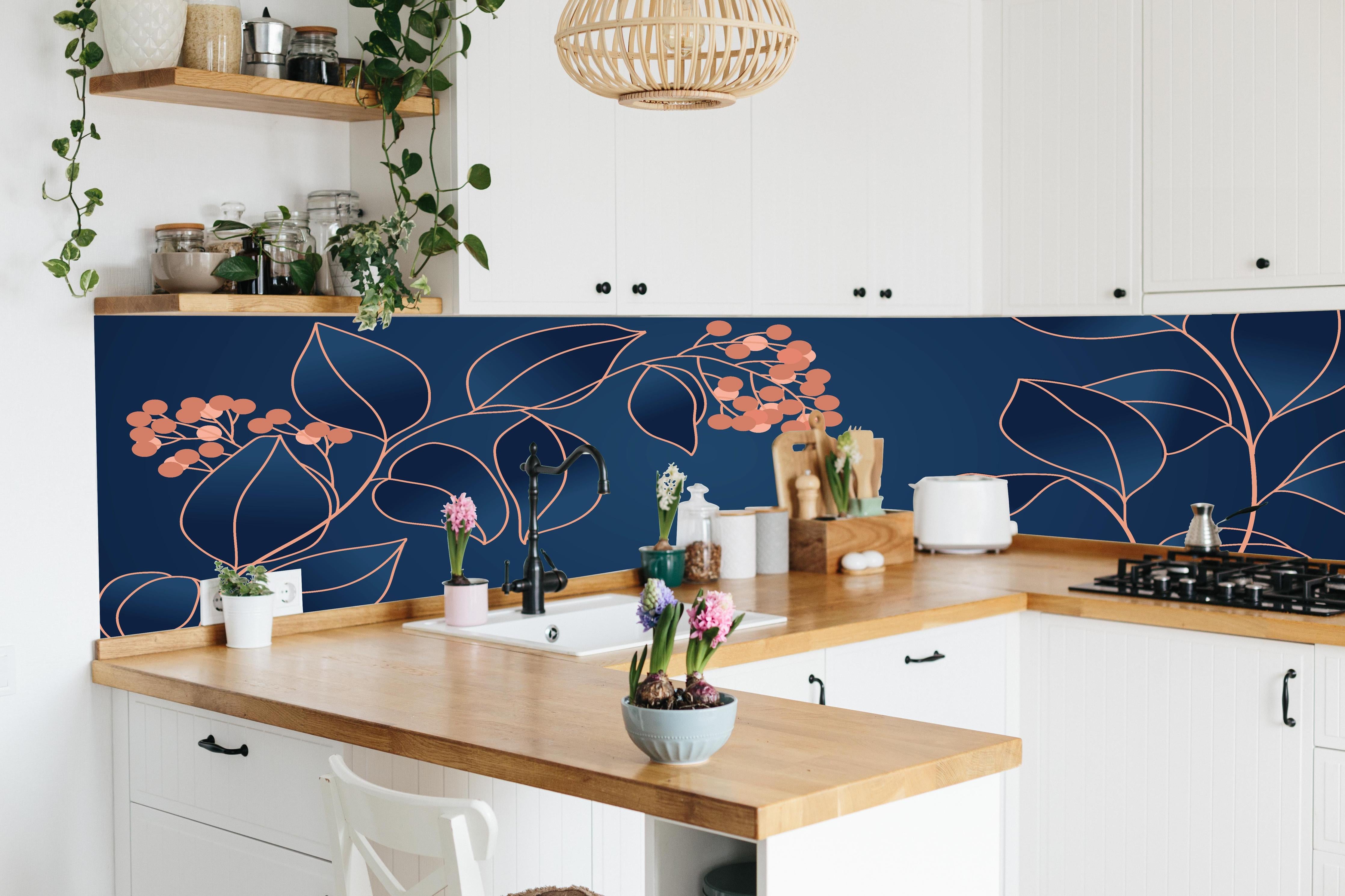 Küche - Grafische Blütenmotive in Blau und Orange hinter weißen Hochglanz-Küchenregalen und schwarzem Wasserhahn