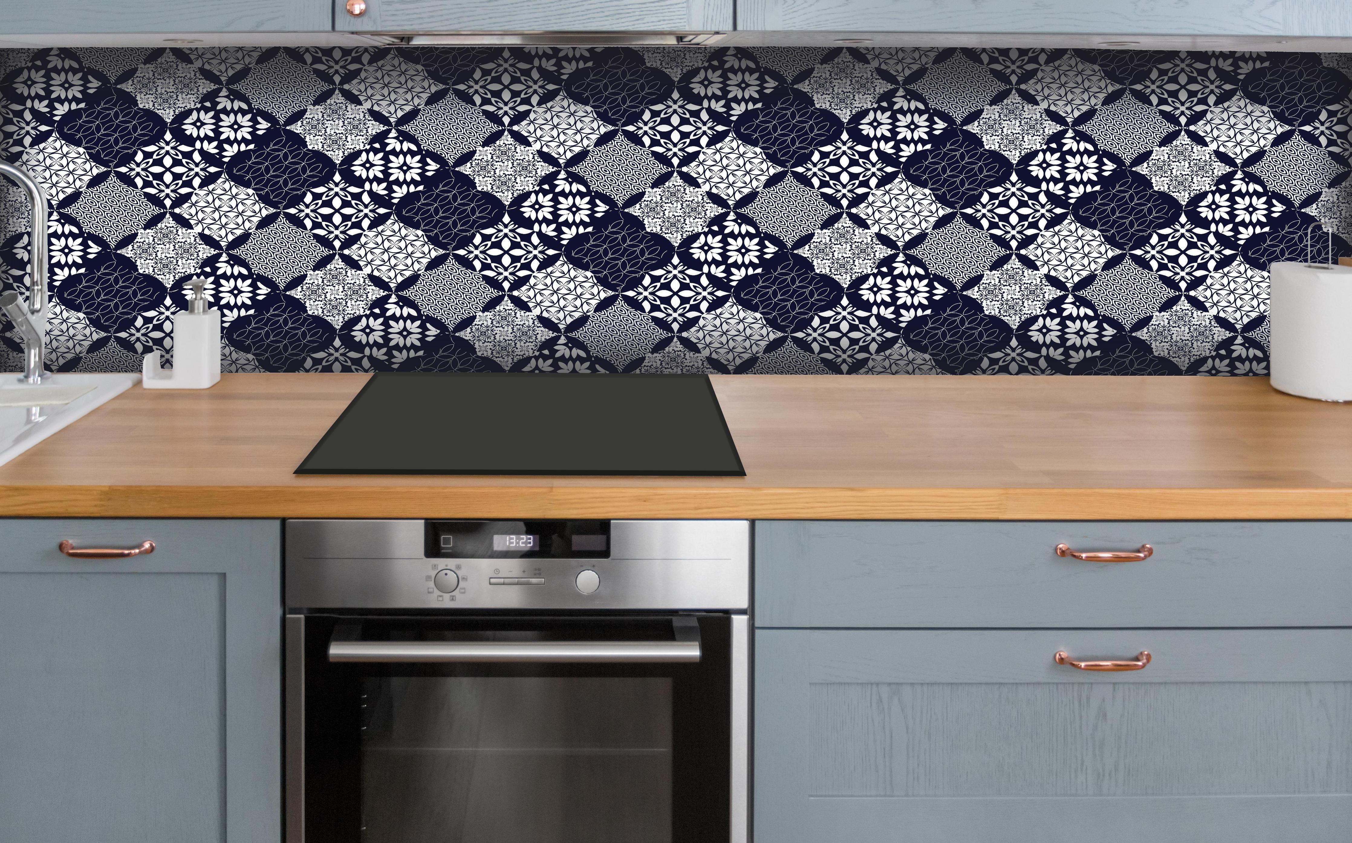 Küche - Grafisches Blau-Weiß-Grau Textildesign hinter weißen Hochglanz-Küchenregalen und schwarzem Wasserhahn