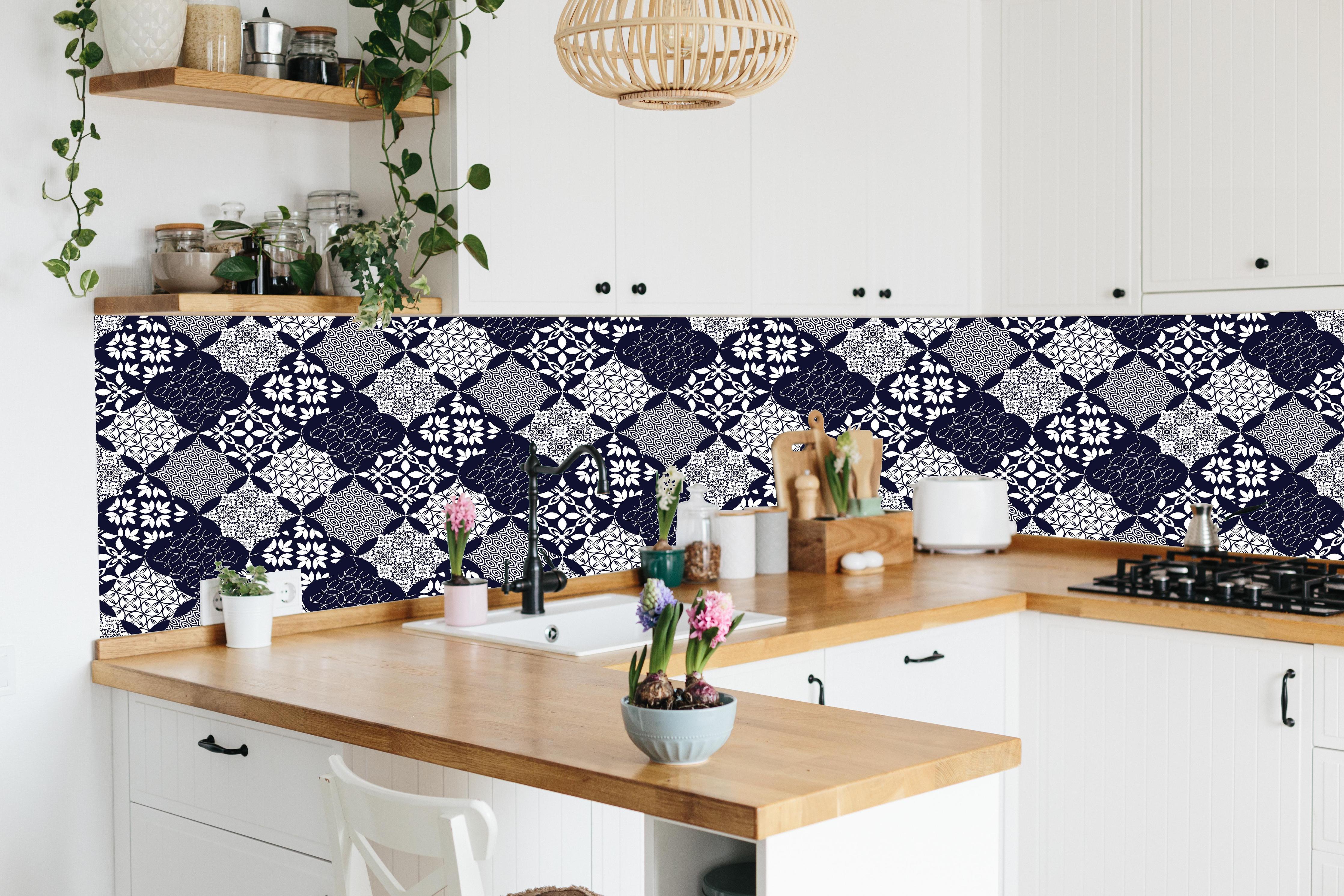 Küche - Grafisches Blau-Weiß-Grau Textildesign hinter weißen Hochglanz-Küchenregalen und schwarzem Wasserhahn