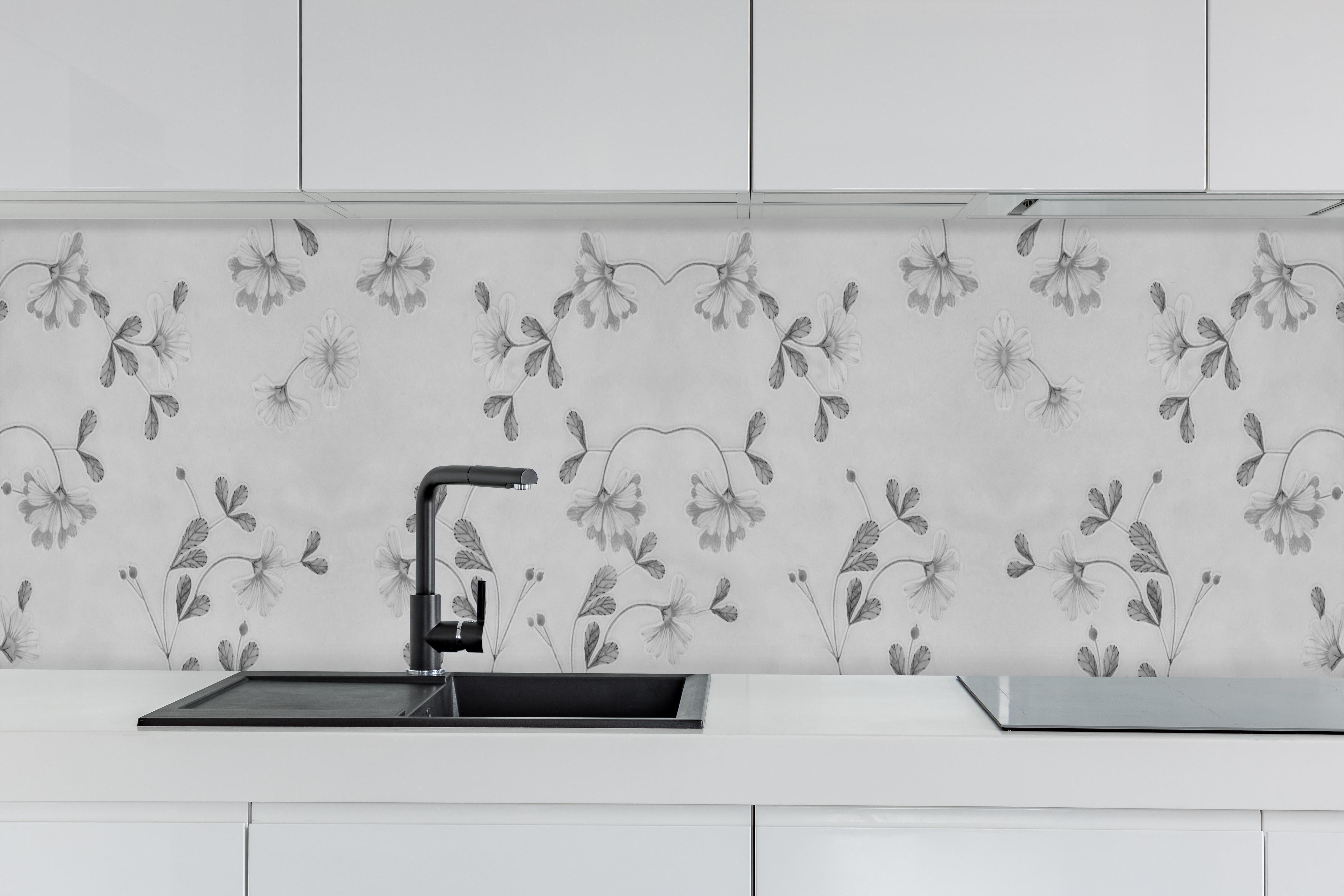 Küche - Grau-Weißes Blumenmuster auf Textil hinter weißen Hochglanz-Küchenregalen und schwarzem Wasserhahn
