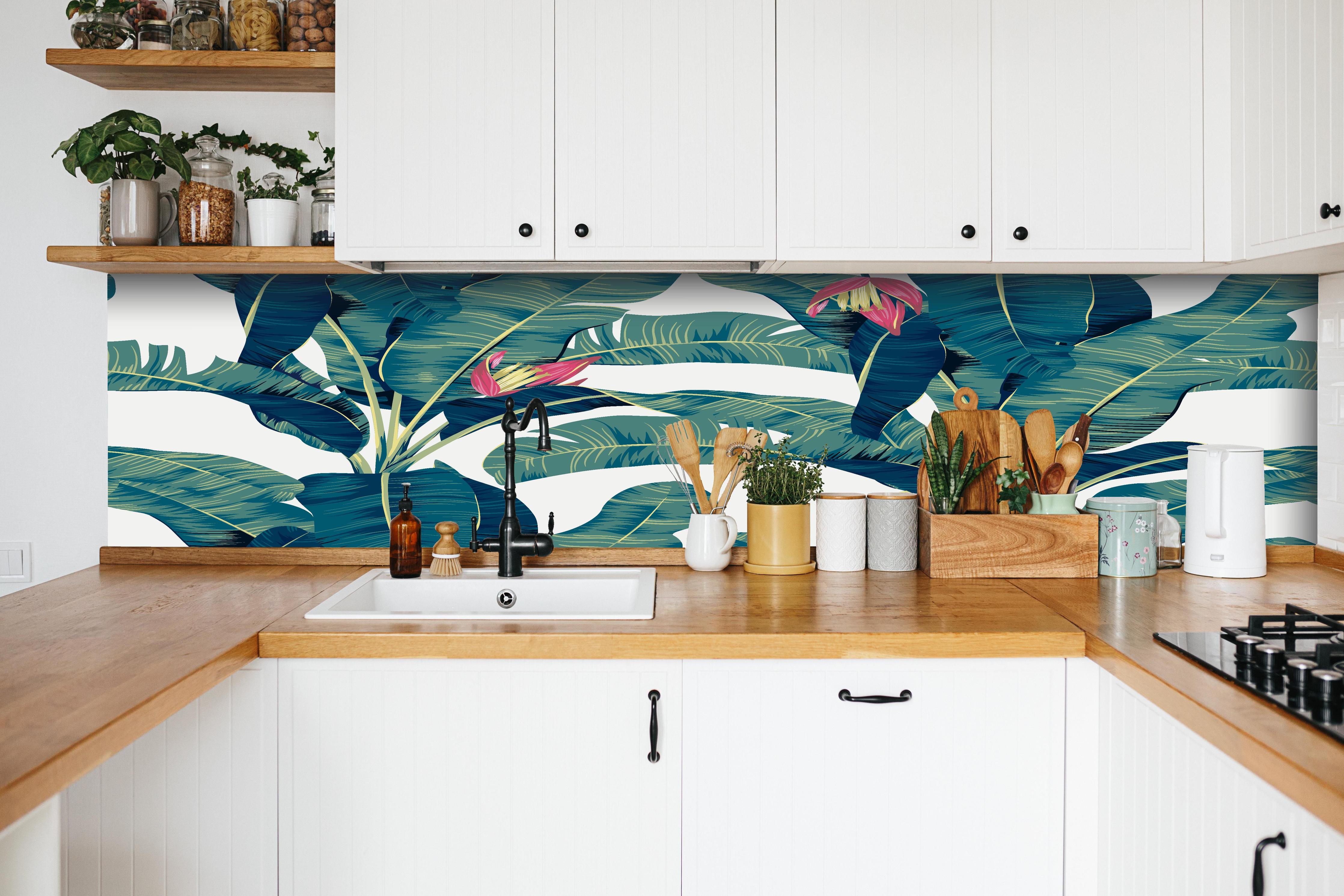 Küche - Grüne Exotische Bananenblätter Illustration hinter weißen Hochglanz-Küchenregalen und schwarzem Wasserhahn