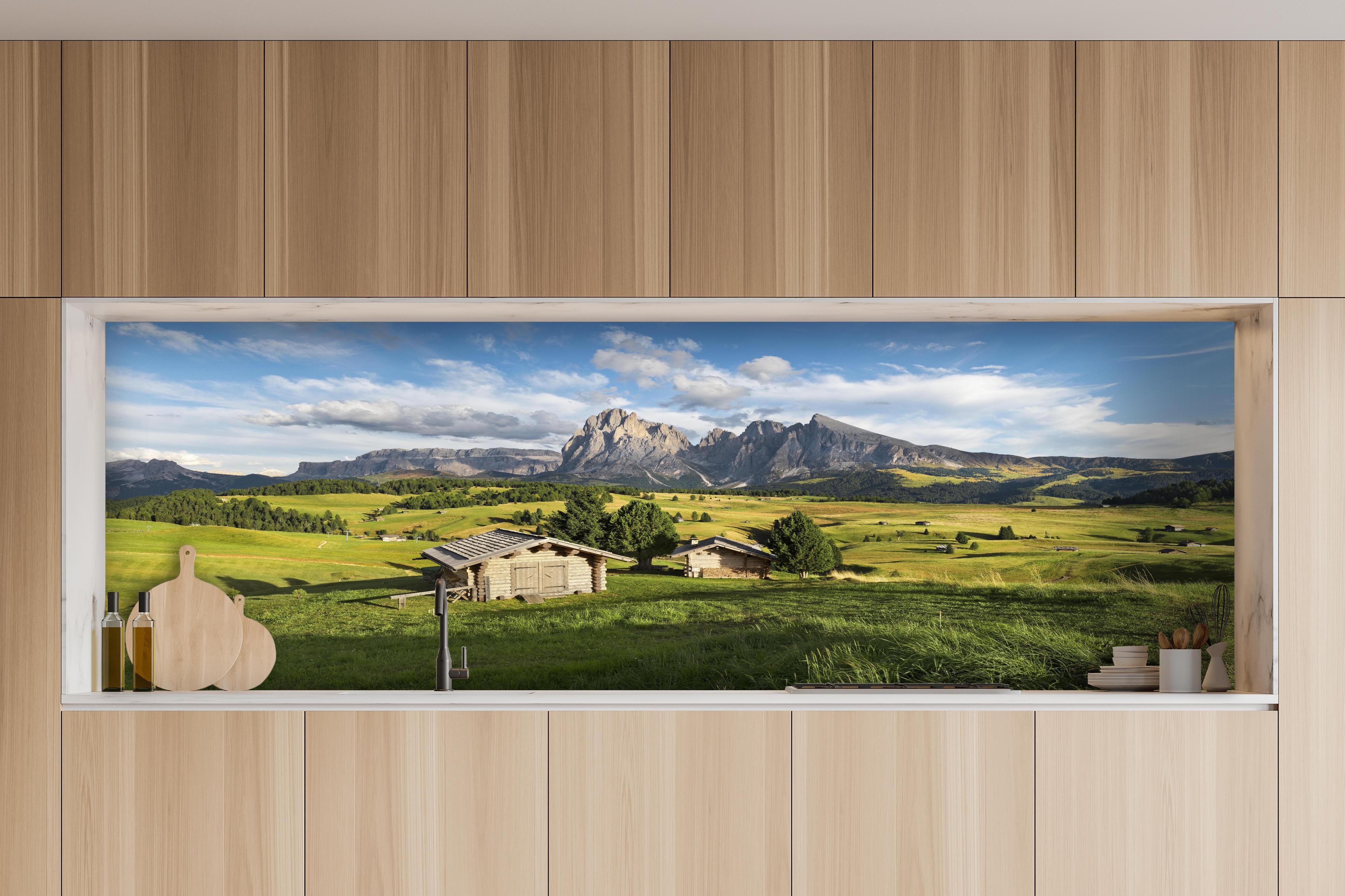 Küche - Idyllische Alpenlandschaft in Sommerfrische hinter weißen Hochglanz-Küchenregalen und schwarzem Wasserhahn