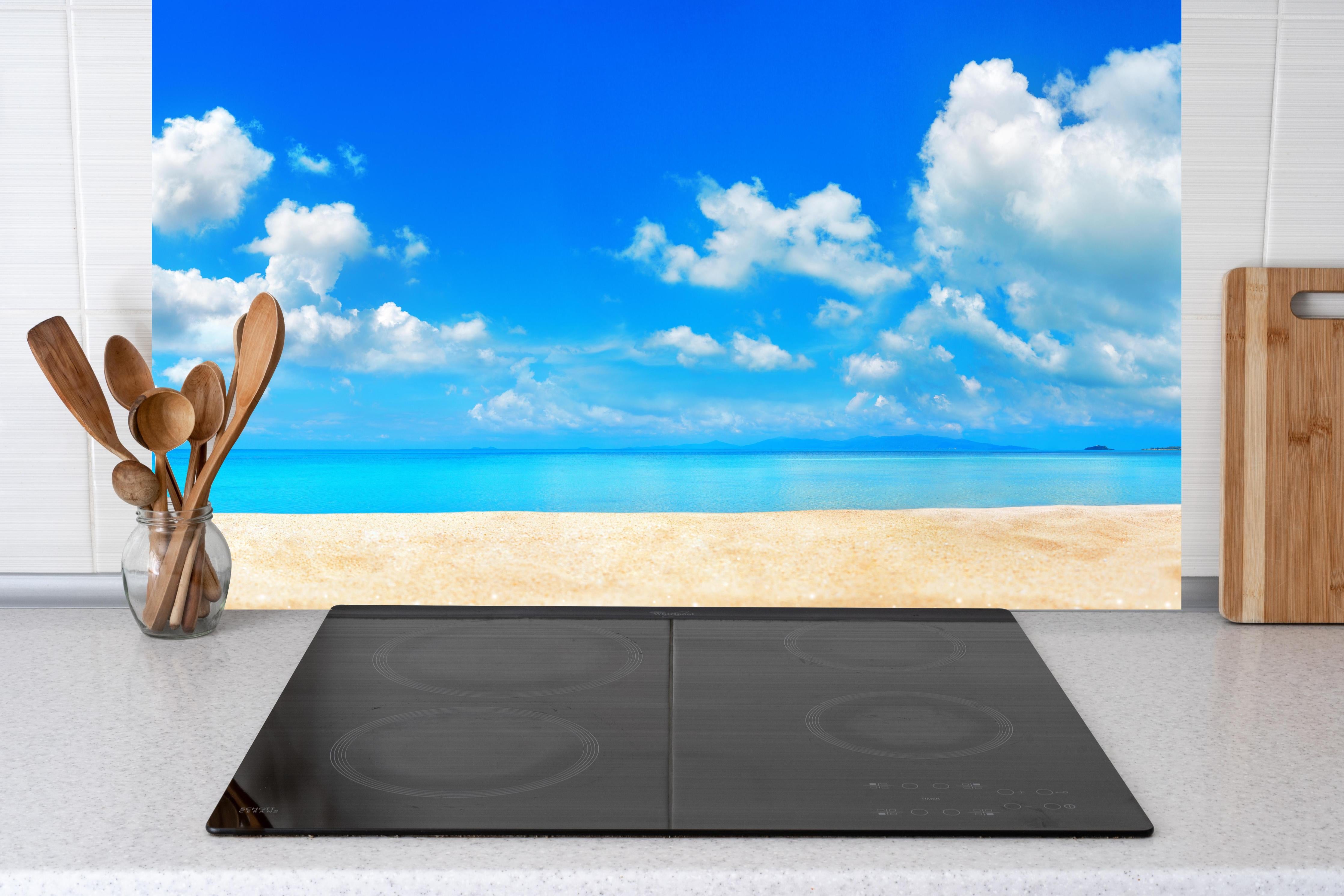 Küche - Idyllische Strandlandschaft mit klarem Wasser und blauem Himmel hinter weißen Hochglanz-Küchenregalen und schwarzem Wasserhahn