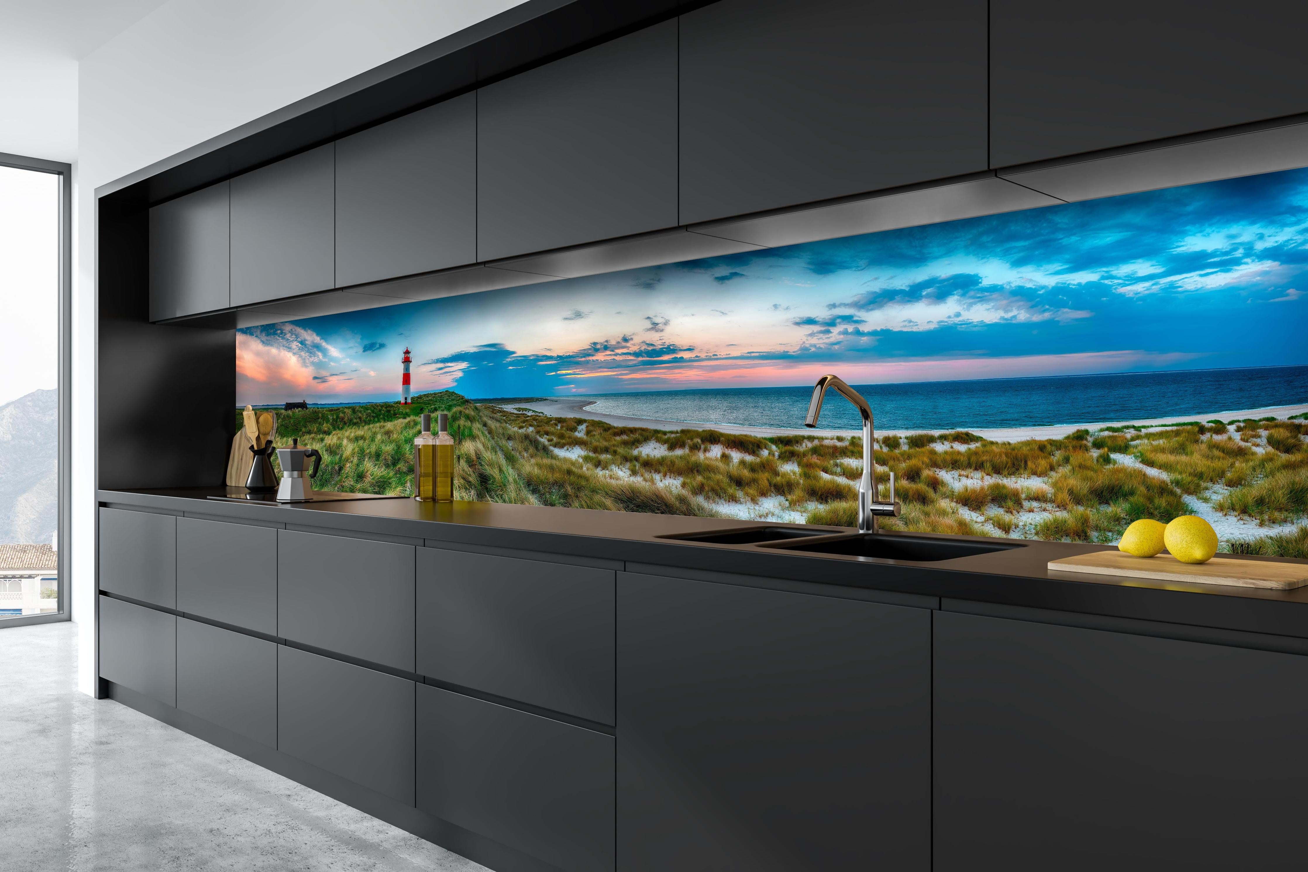 Küche - Idyllischer Leuchtturm mit traumhaften Ausblick auf den Sonnenuntergang am Meer hinter weißen Hochglanz-Küchenregalen und schwarzem Wasserhahn