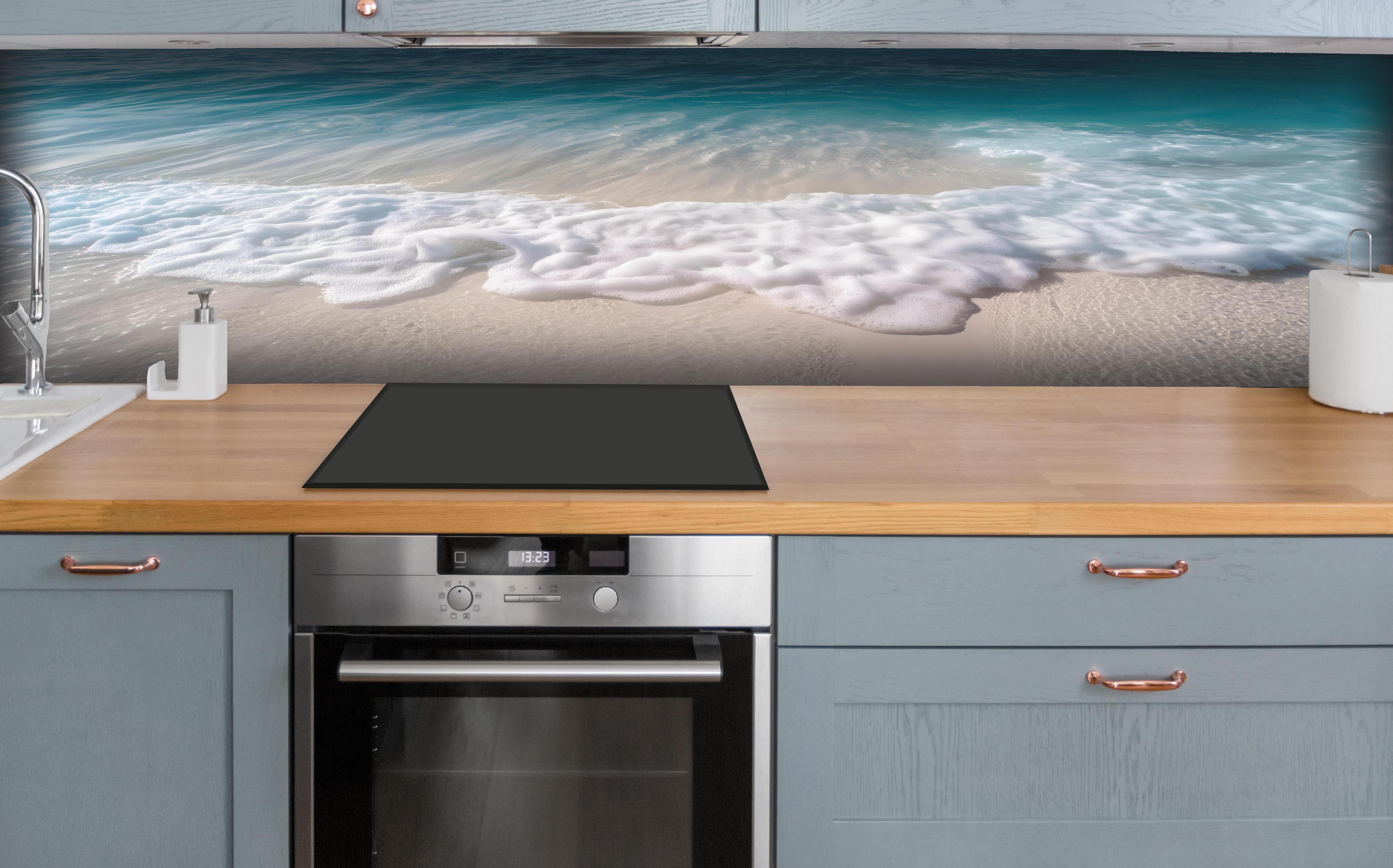 Küche - Idyllischer Strand mit sanften Wellen und weißem Schaum hinter weißen Hochglanz-Küchenregalen und schwarzem Wasserhahn