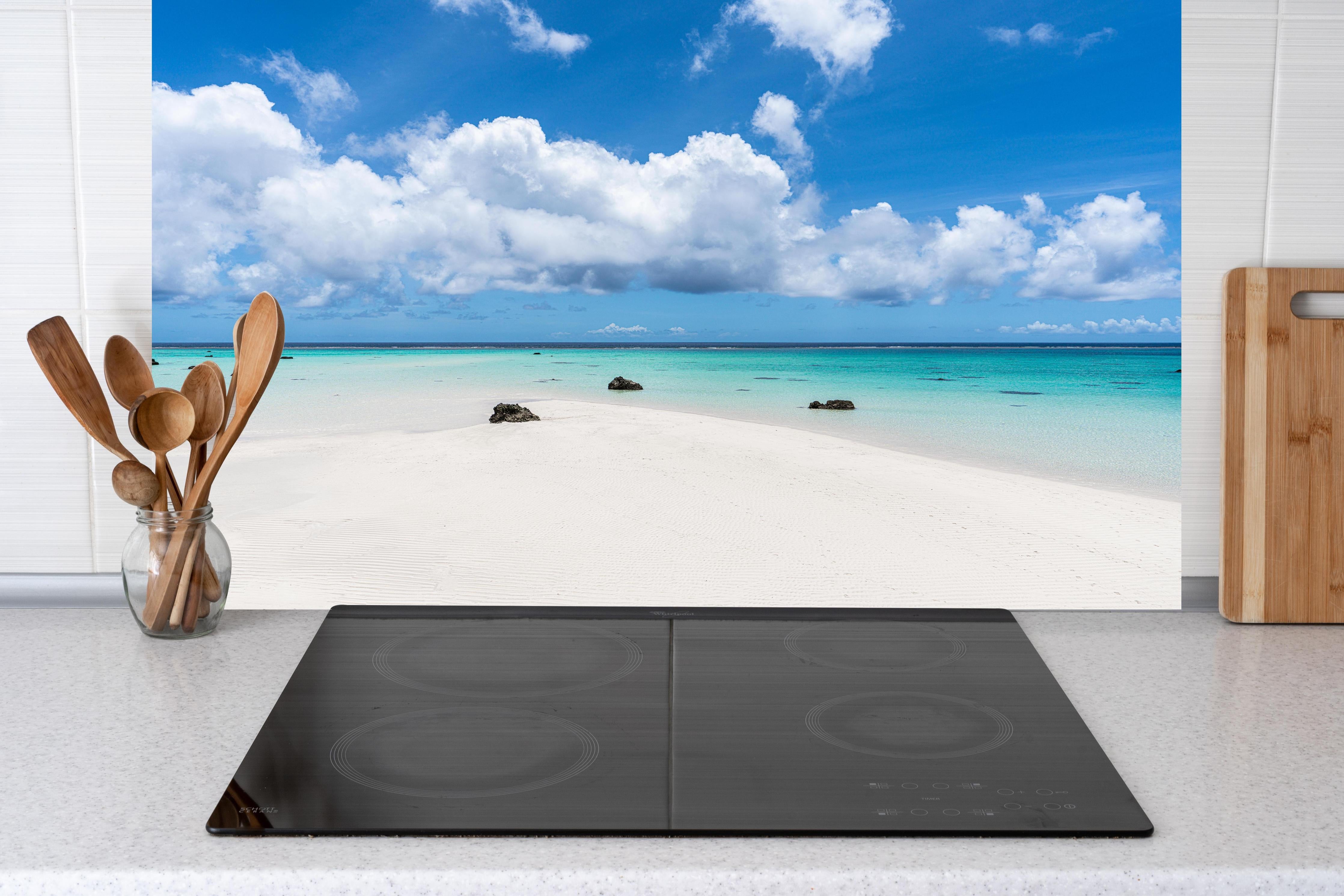 Küche - Idyllischer tropischer Strand mit kristallklarem Wasser und Wolkenhimmel hinter weißen Hochglanz-Küchenregalen und schwarzem Wasserhahn