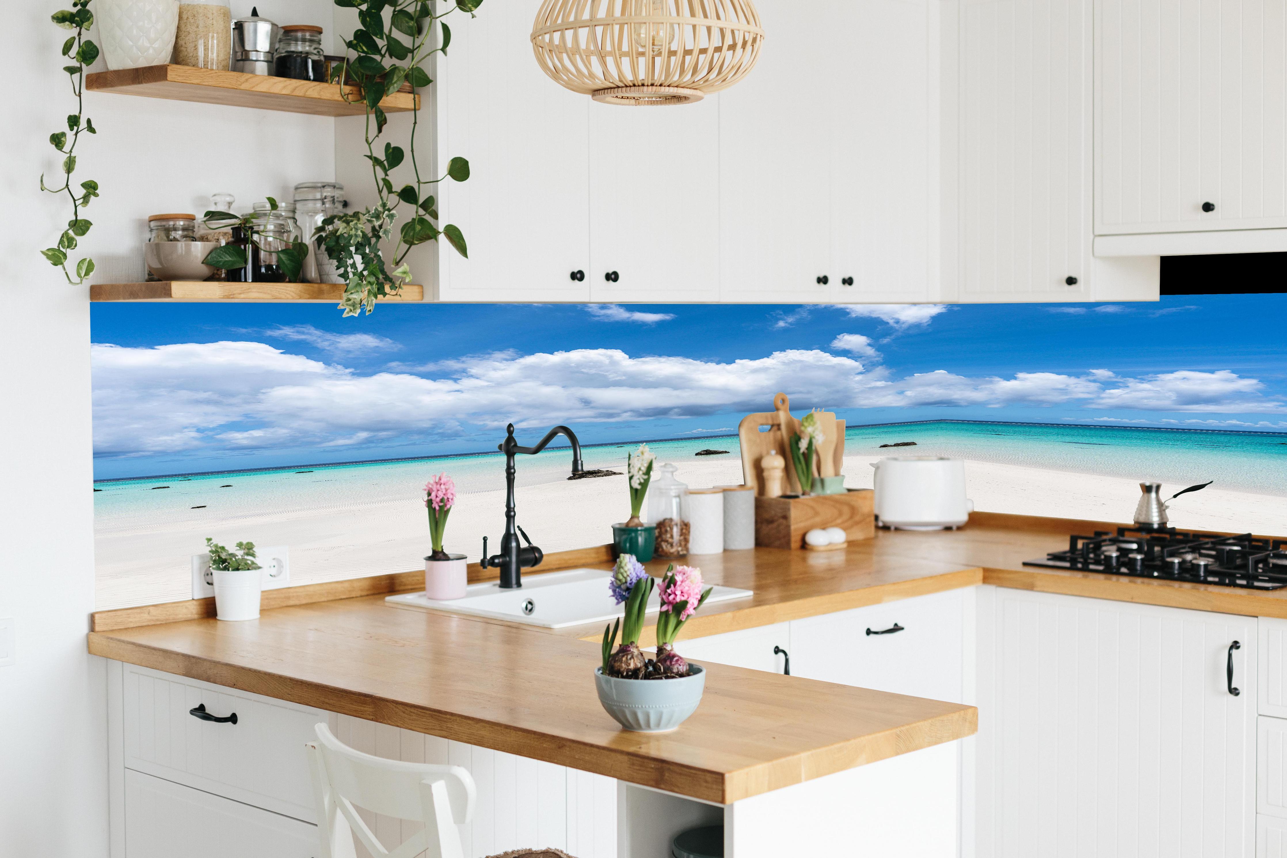 Küche - Idyllischer tropischer Strand mit kristallklarem Wasser und Wolkenhimmel hinter weißen Hochglanz-Küchenregalen und schwarzem Wasserhahn