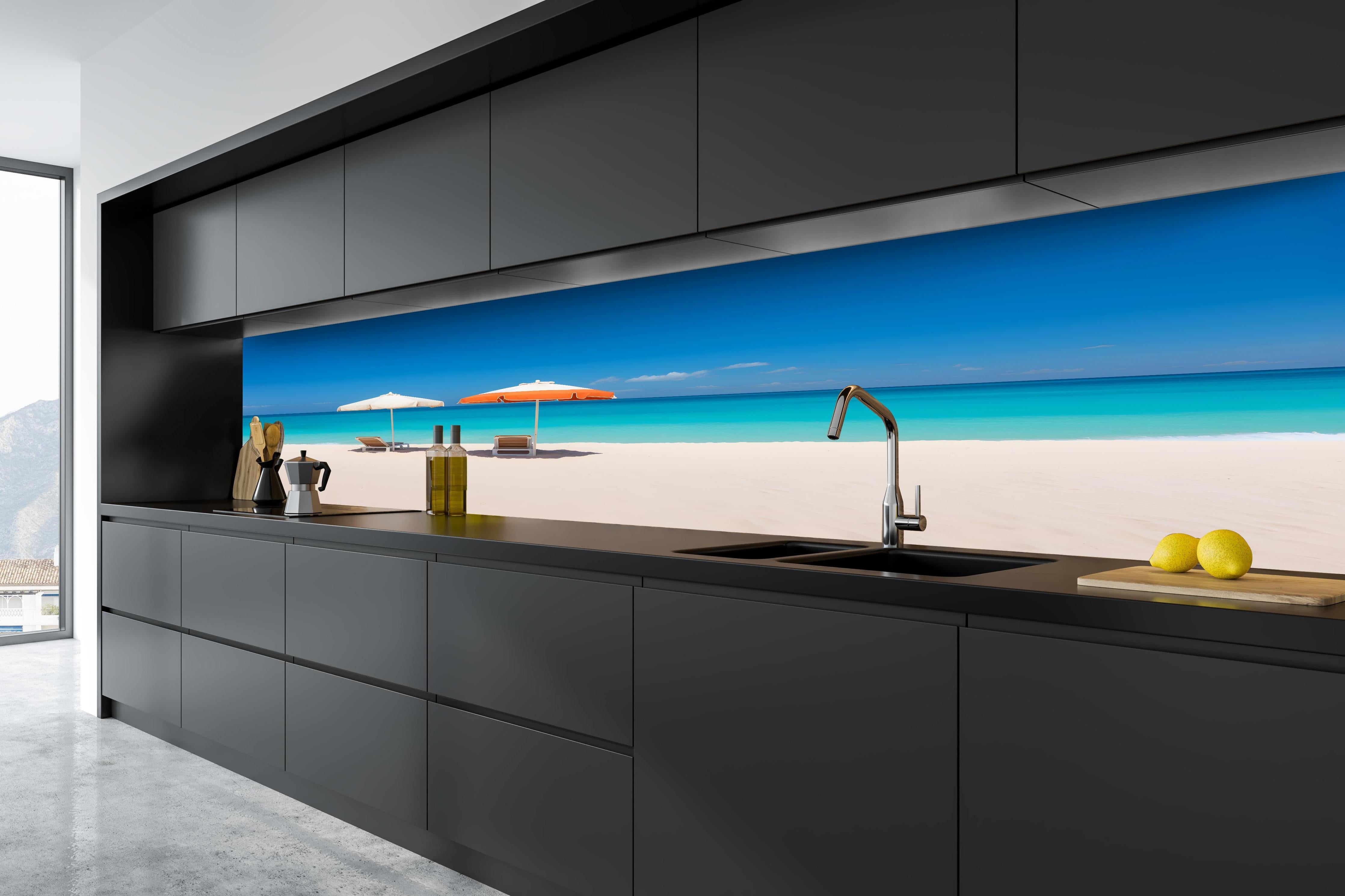 Küche - Idyllischer tropischer Strand mit weißen Sand und sonnigen Schirmen hinter weißen Hochglanz-Küchenregalen und schwarzem Wasserhahn