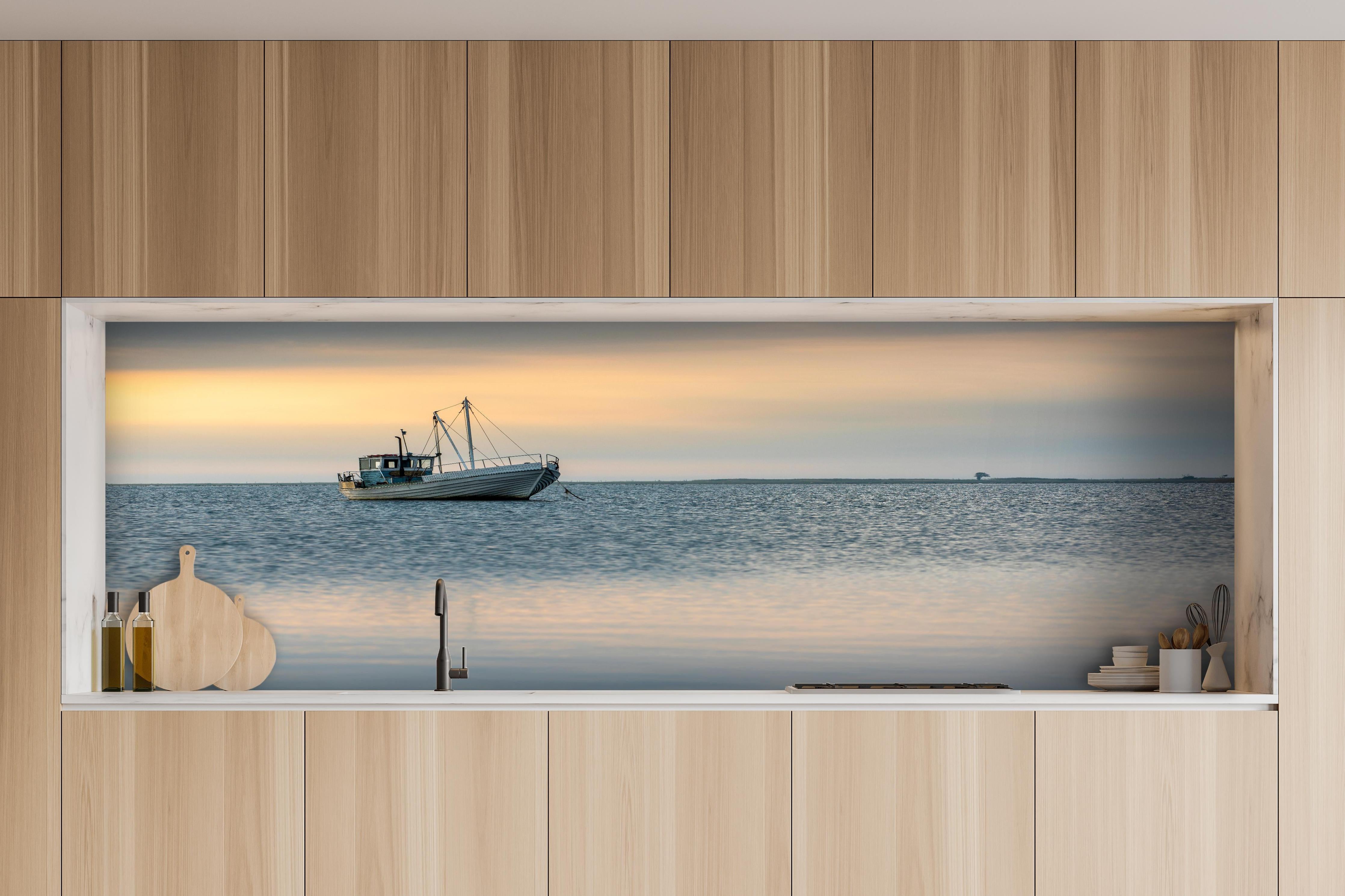 Küche - Idyllisches Boot auf ruhigem Wasser bei Sonnenuntergang hinter weißen Hochglanz-Küchenregalen und schwarzem Wasserhahn