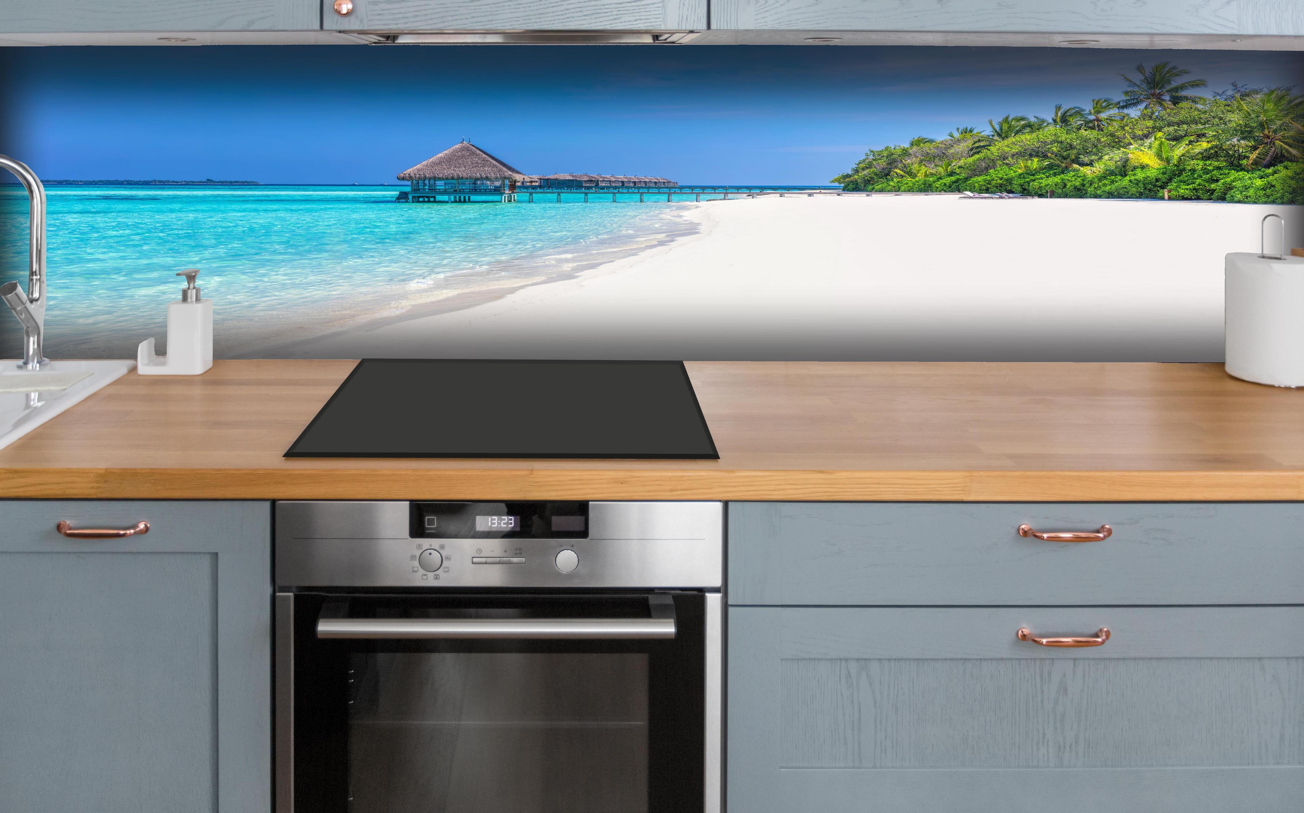 Küche - Idyllisches tropisches Paradies mit türkisblauem Wasser und weißem Sandstrand hinter weißen Hochglanz-Küchenregalen und schwarzem Wasserhahn