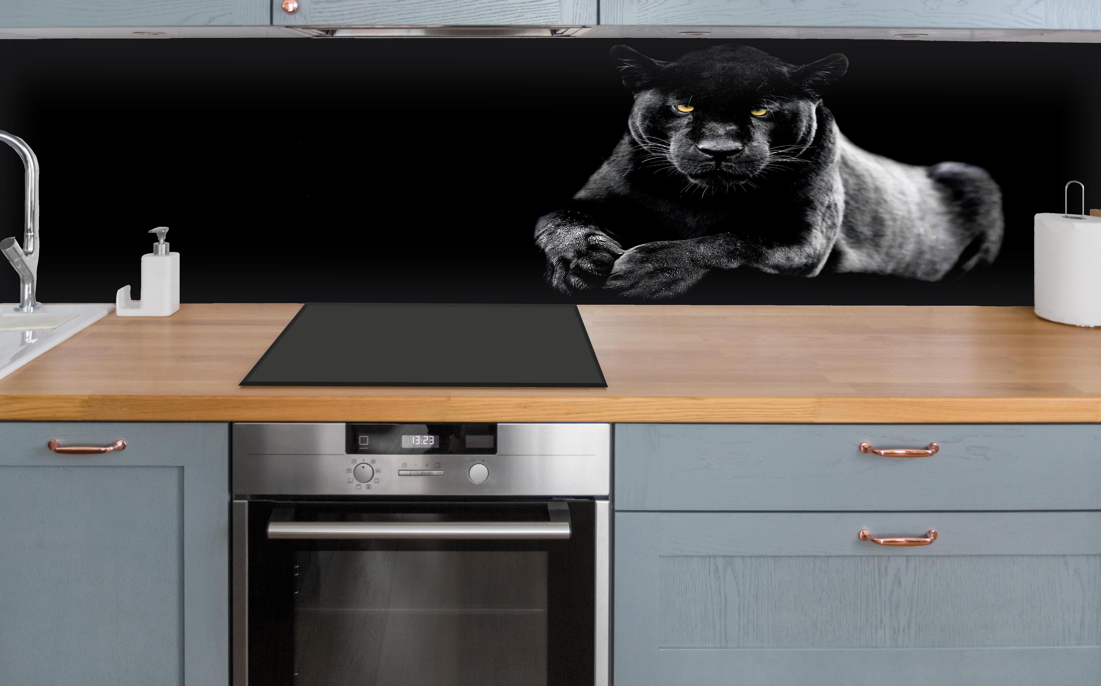 Küche - Jaguar auf schwarzem Hintergrund hinter weißen Hochglanz-Küchenregalen und schwarzem Wasserhahn