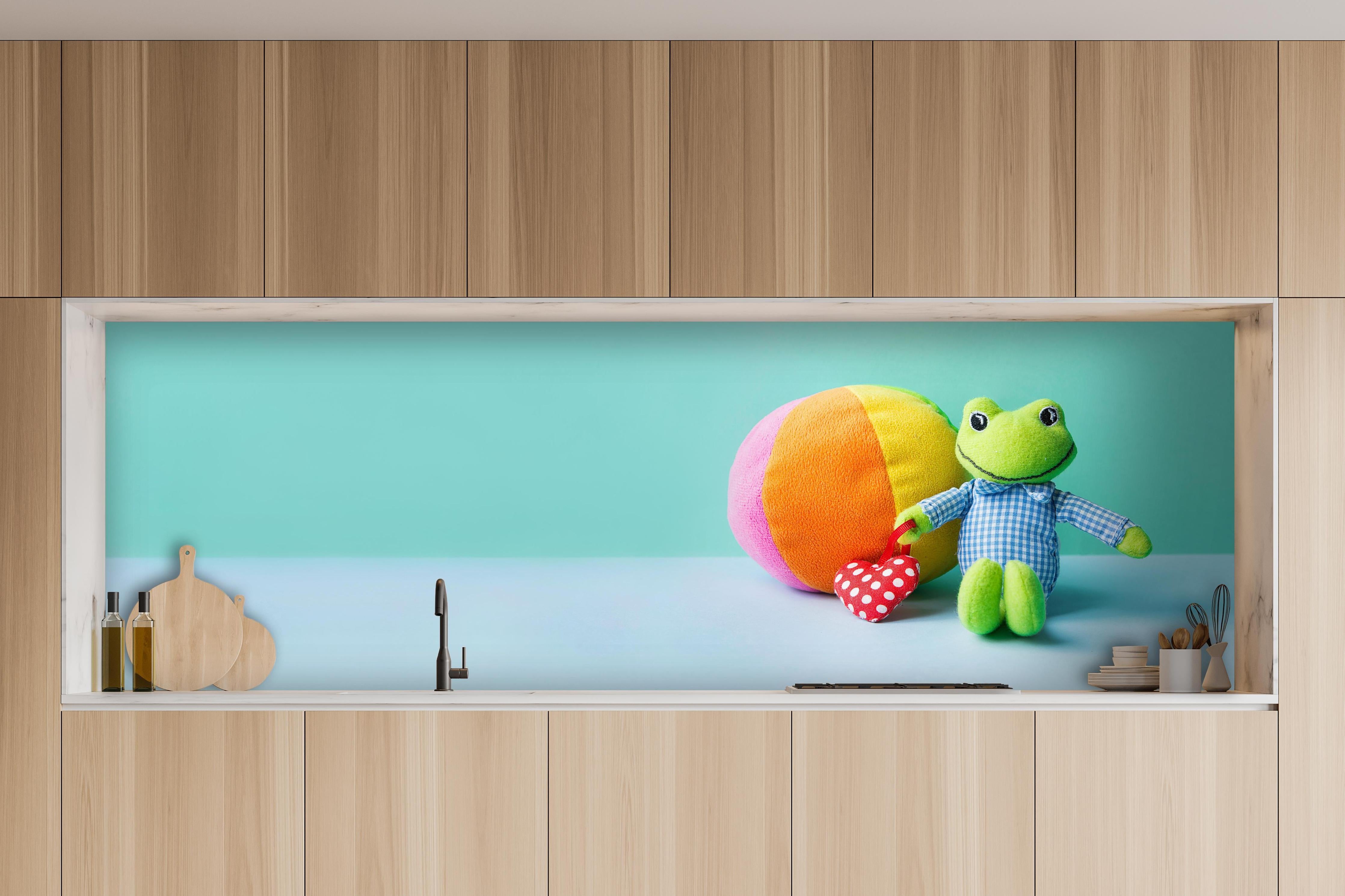 Küche - Kinderspielzeug Kleiner Frosch hinter weißen Hochglanz-Küchenregalen und schwarzem Wasserhahn