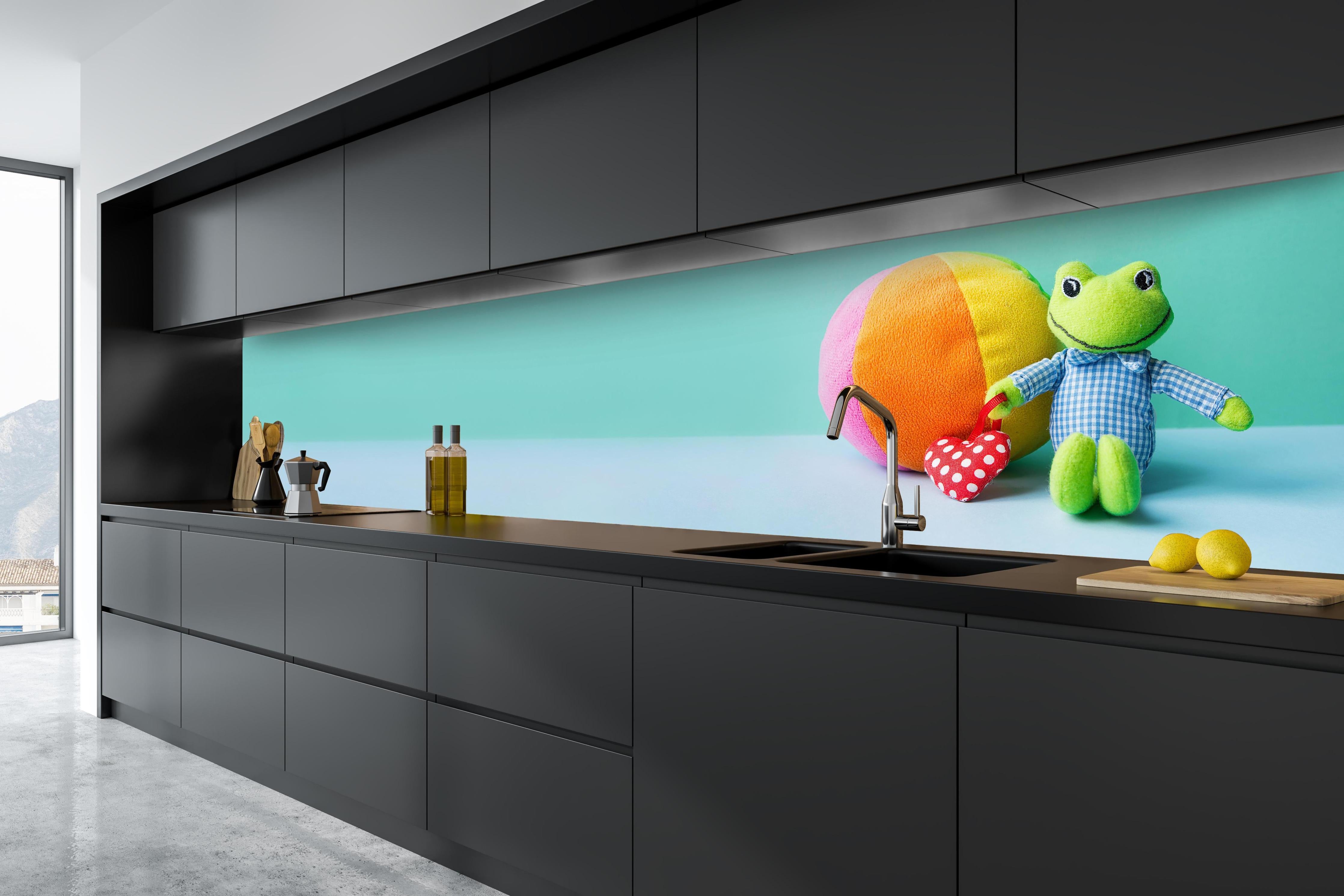 Küche - Kinderspielzeug Kleiner Frosch hinter weißen Hochglanz-Küchenregalen und schwarzem Wasserhahn