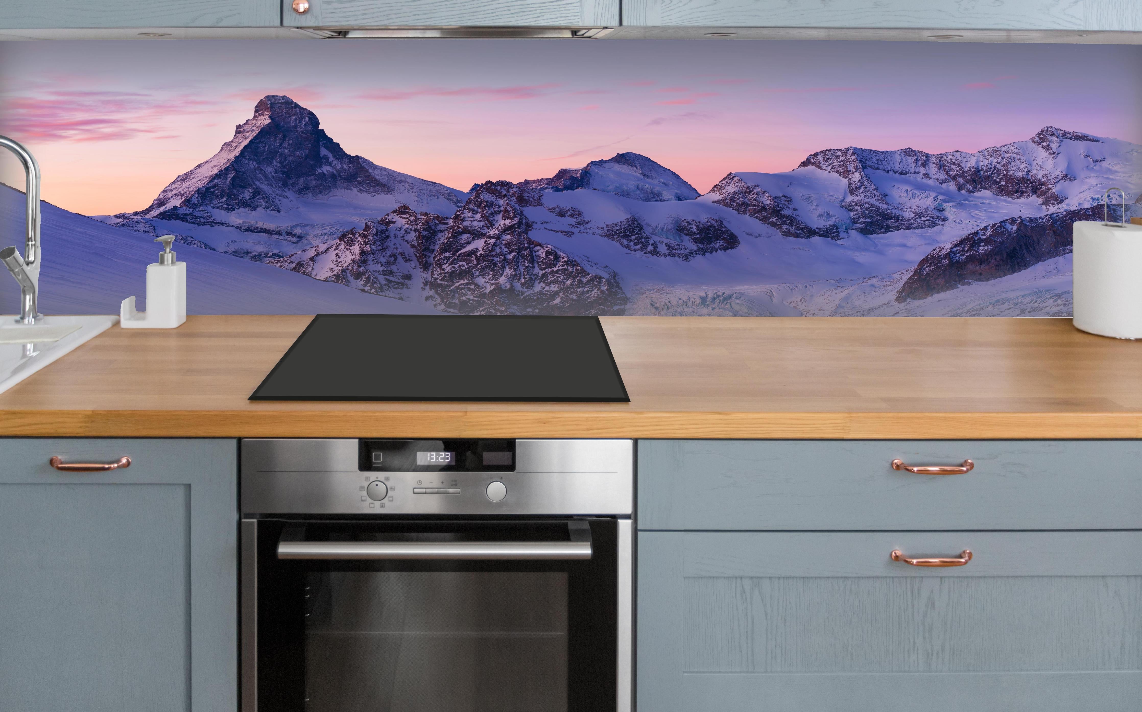 Küche - Alpenpanorama Sonnenuntergang Weiß-Rosa über polierter Holzarbeitsplatte mit Cerankochfeld