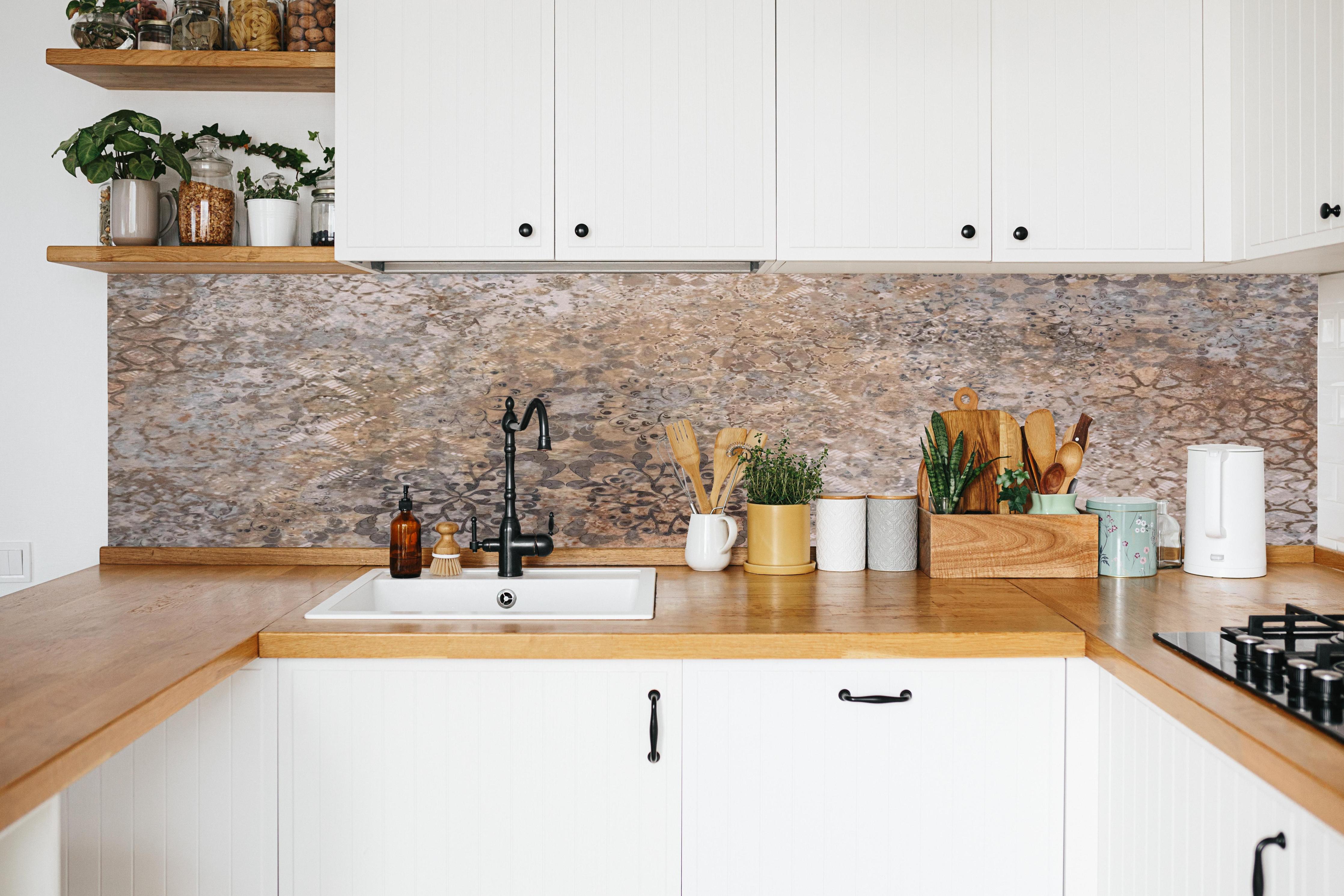 Küche - Beige-Braun Vintage-Fliesenmuster in weißer Küche hinter Gewürzen und Kochlöffeln aus Holz