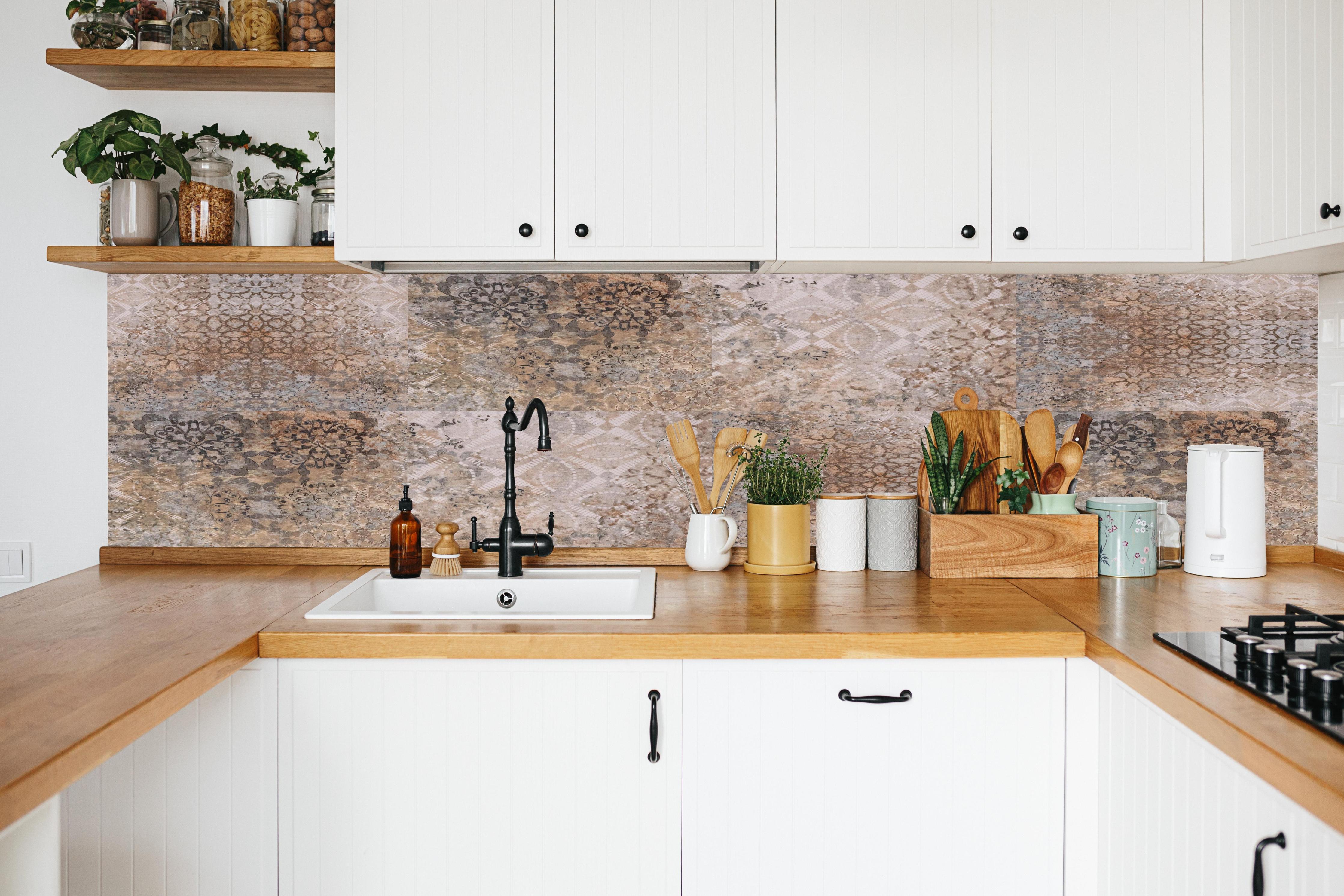 Küche - Beige-Grau Vintage-Fliesen in weißer Küche hinter Gewürzen und Kochlöffeln aus Holz
