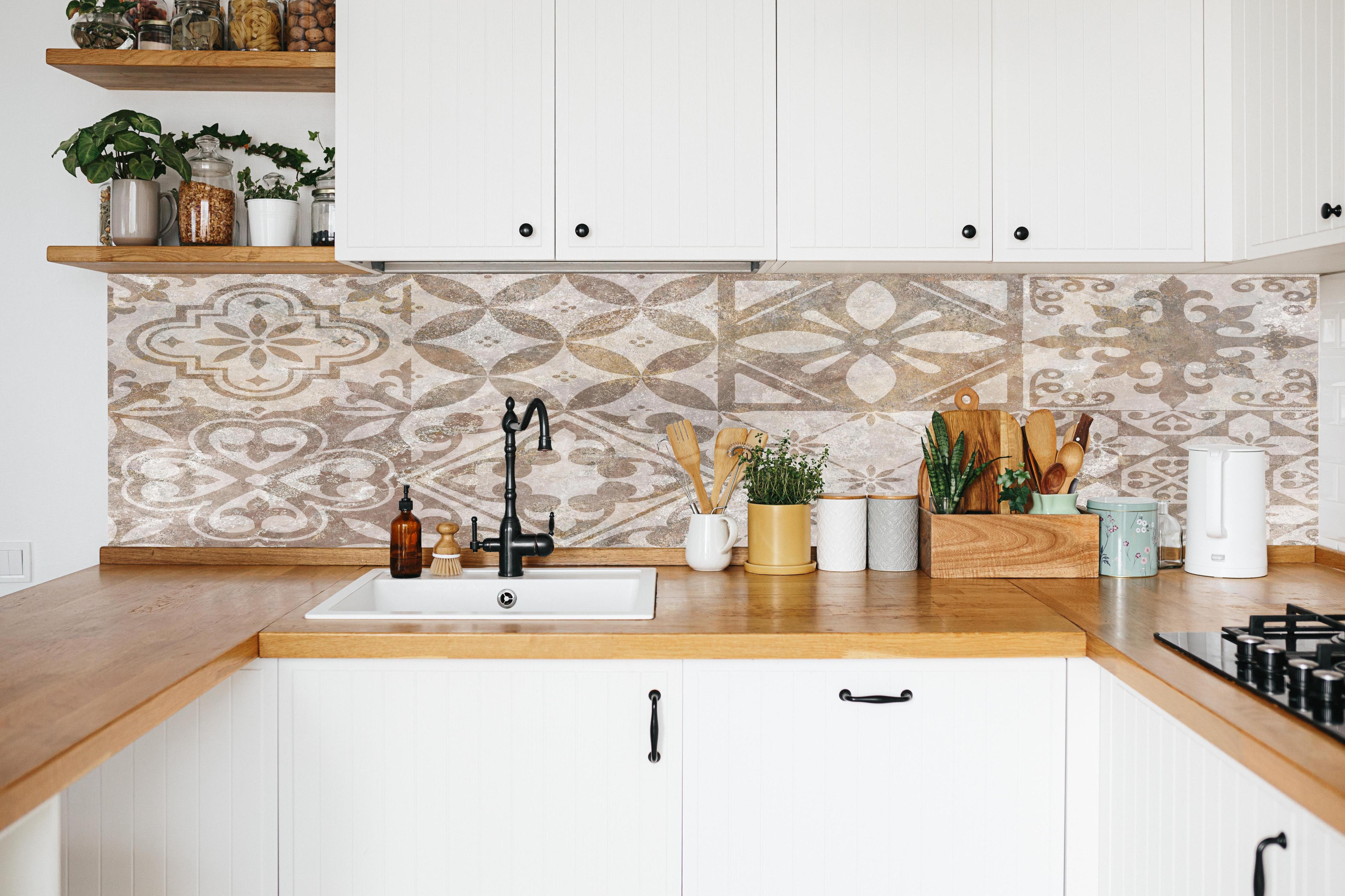 Küche - Beige-Grau-Vintage-Fliesenmuster in weißer Küche hinter Gewürzen und Kochlöffeln aus Holz