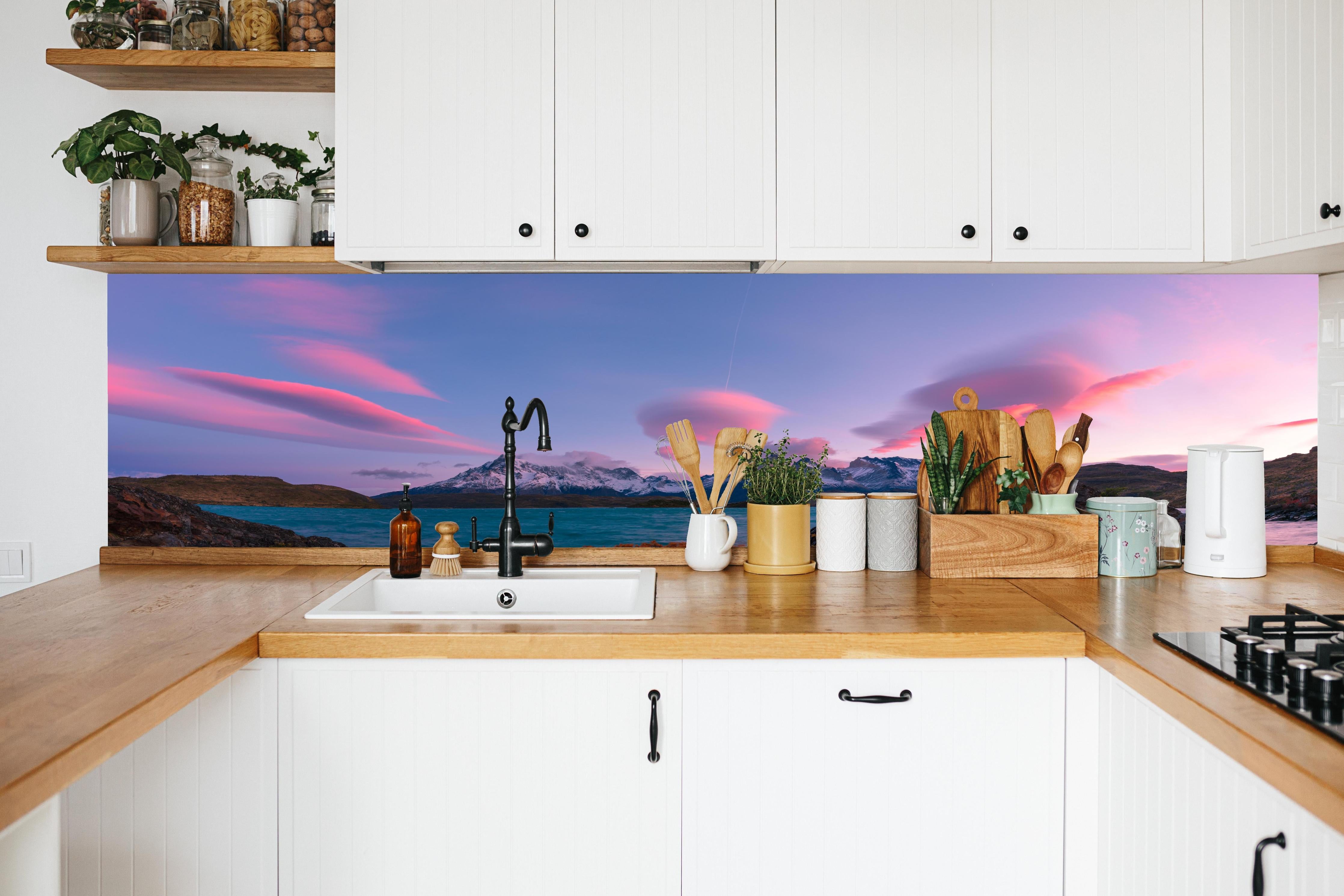 Küche - Bergpanorama im rosa Sonnenuntergang in weißer Küche hinter Gewürzen und Kochlöffeln aus Holz