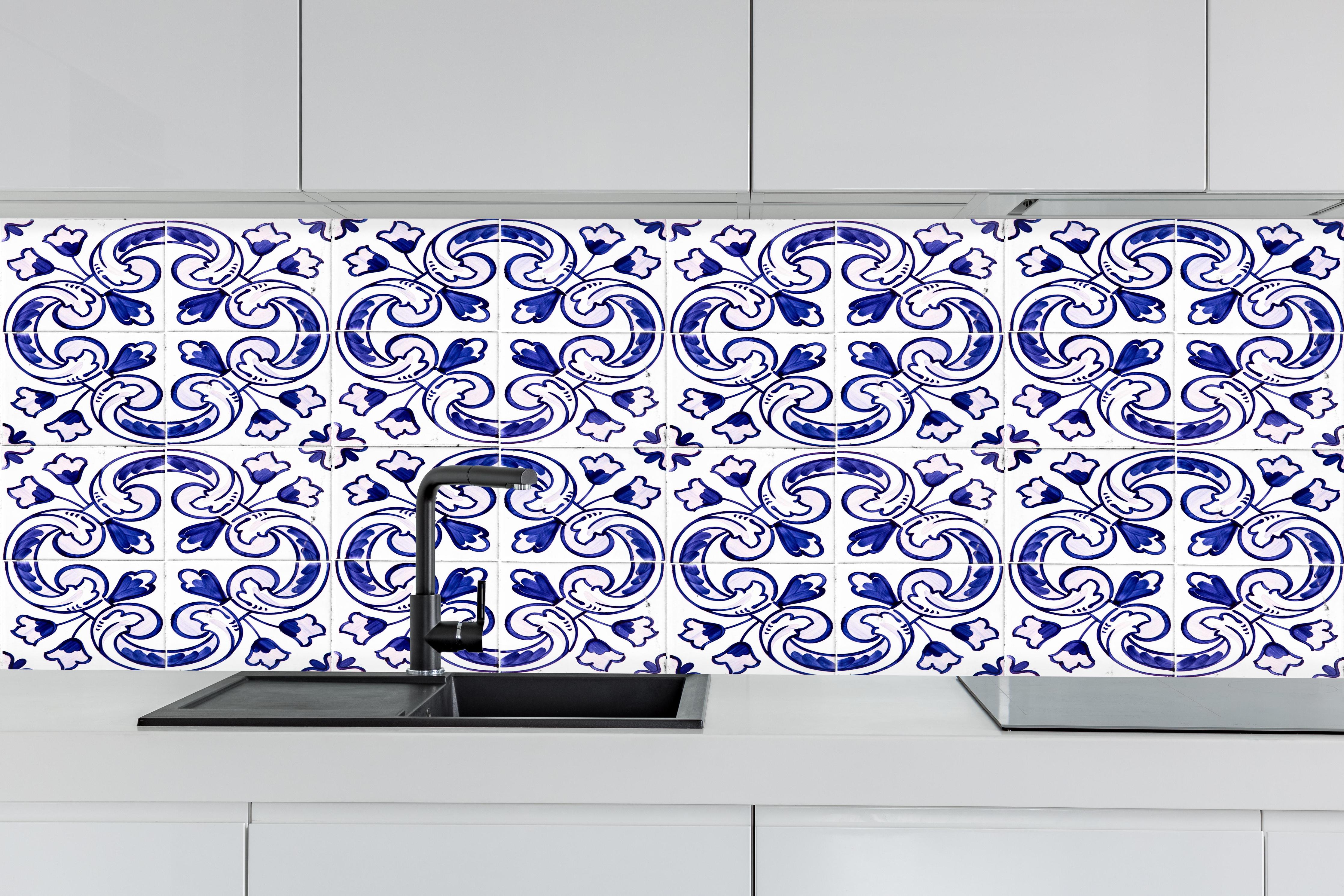 Küche - Blau-Weiß Fliesenmuster hinter weißen Hochglanz-Küchenregalen und schwarzem Wasserhahn
